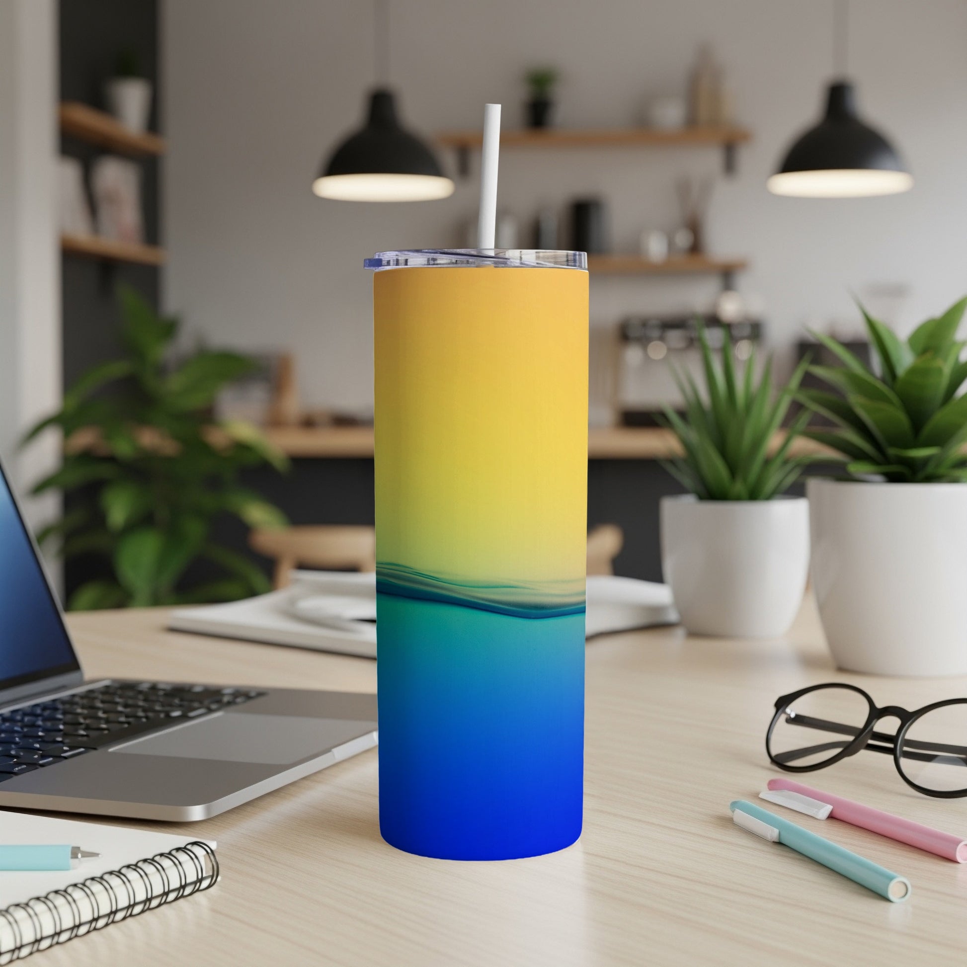 Yellow to blue gradient tumbler with white straw on a desk.