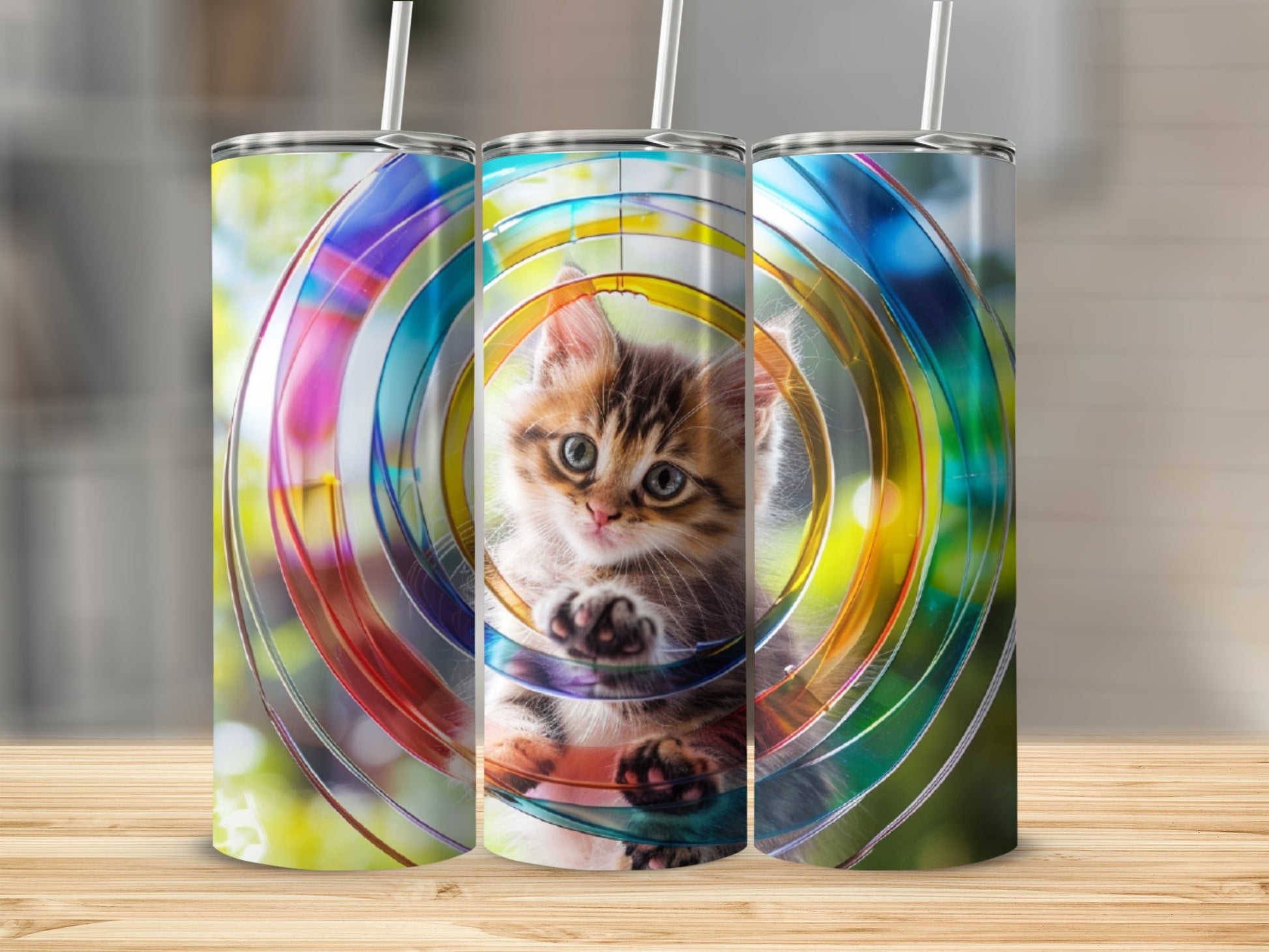 Kitten peeking through colorful rainbow rings, with straws.
