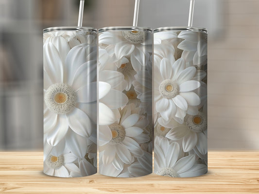 Three white floral tumblers with straws on a wooden surface.