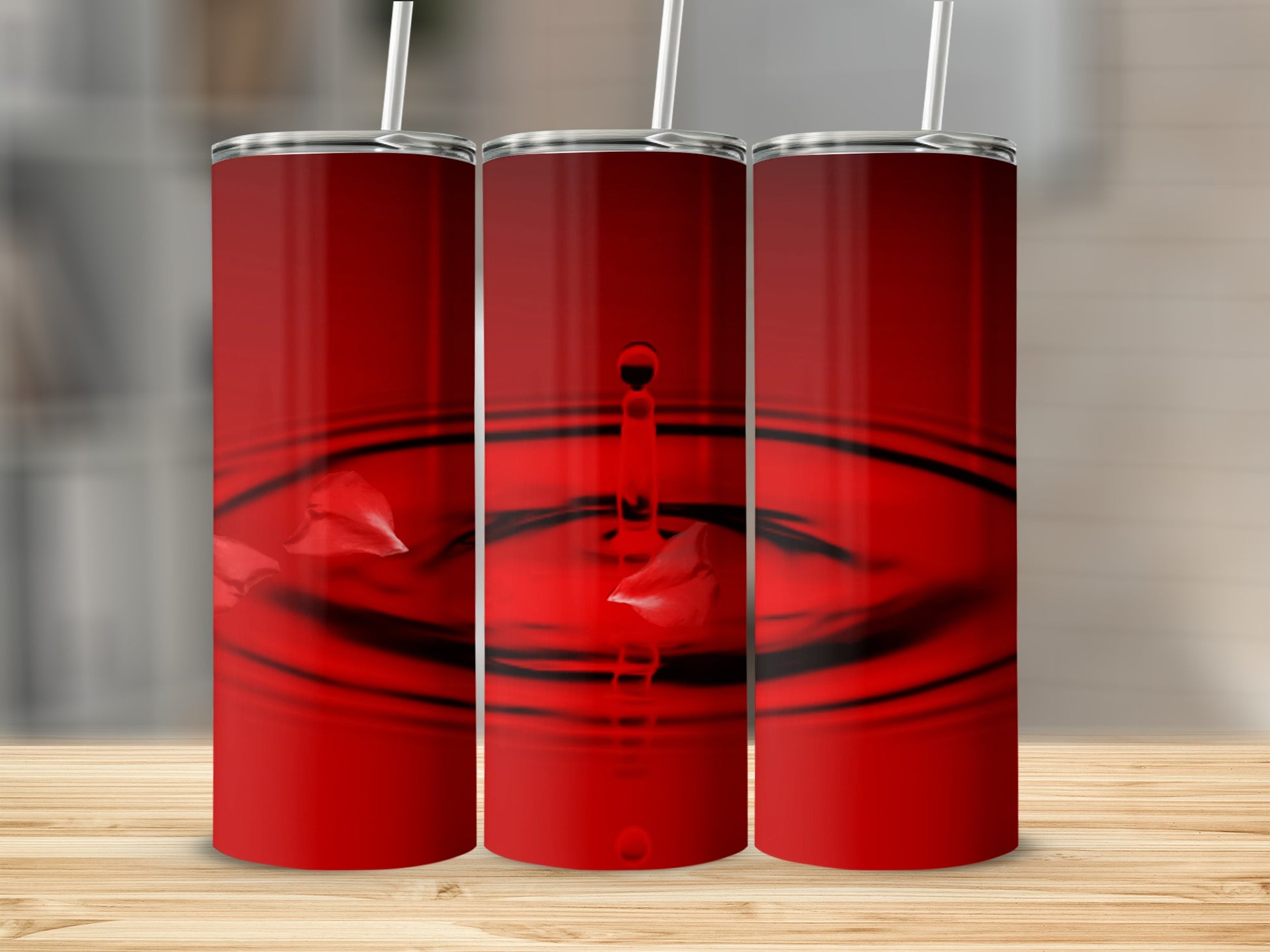 Three red tumblers with water ripple and petal graphics.