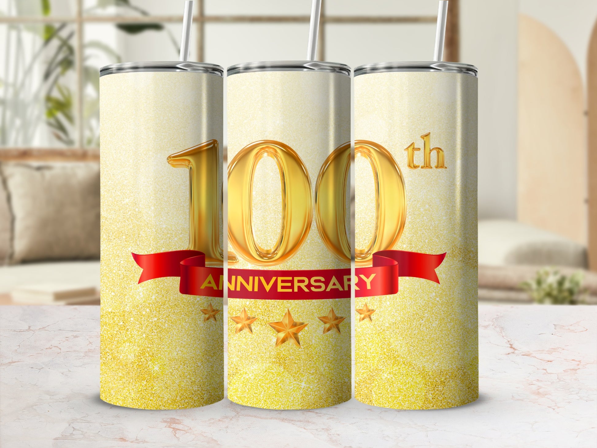 Three gold glitter tumblers with "100th" anniversary text and a red ribbon.