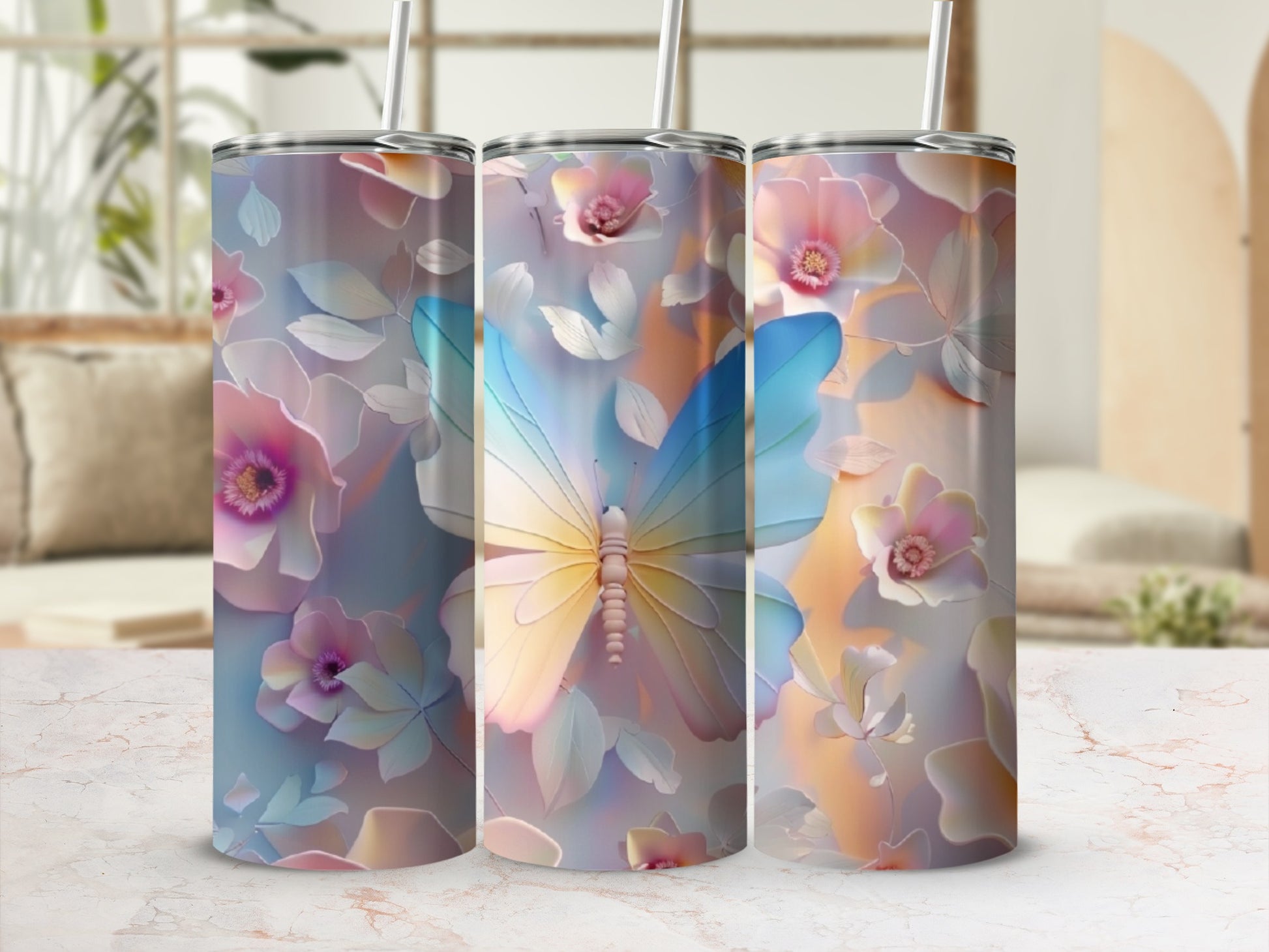 Three tumblers with butterfly and floral designs, on a marble surface.