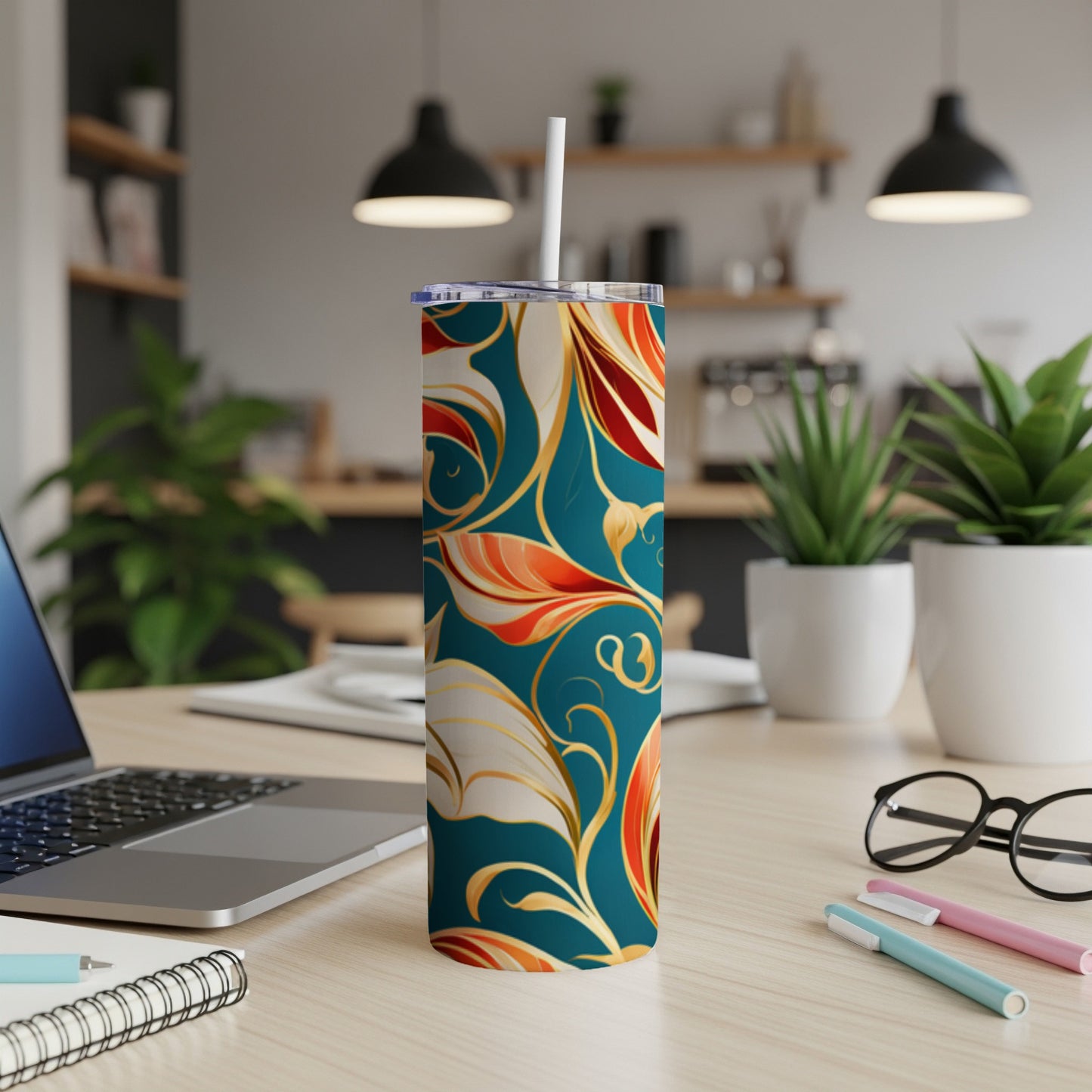 Teal tumbler with ornate gold and red floral pattern, with straw.
