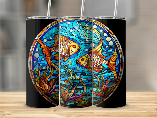 Two goldfish swim among colorful reeds in a circular stained glass design on a tumbler.