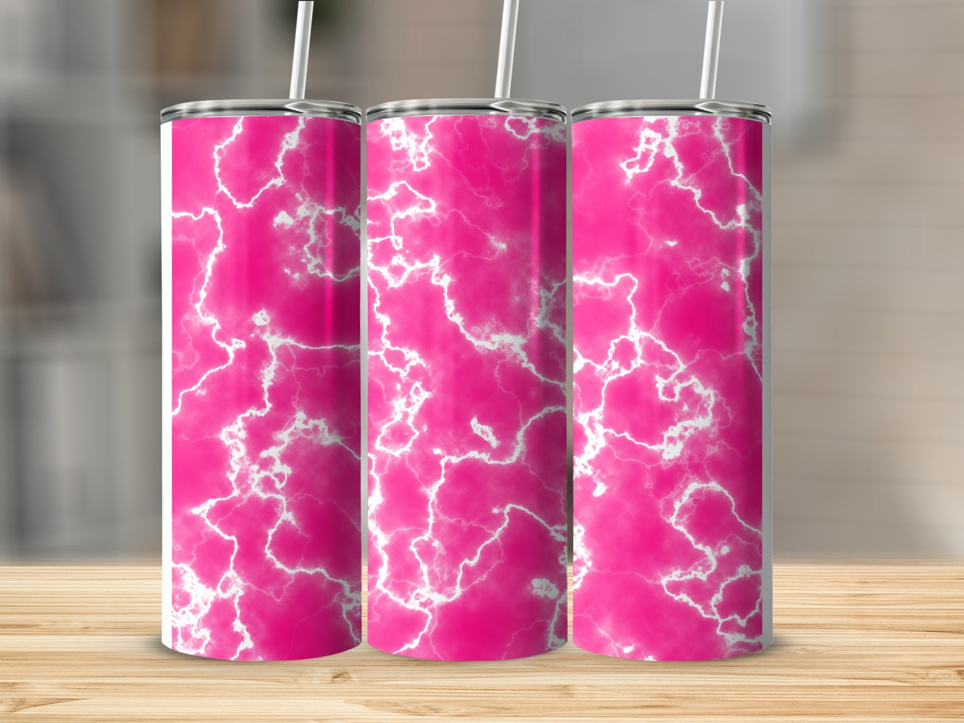 Three pink tumblers with white marble pattern on a wooden surface.