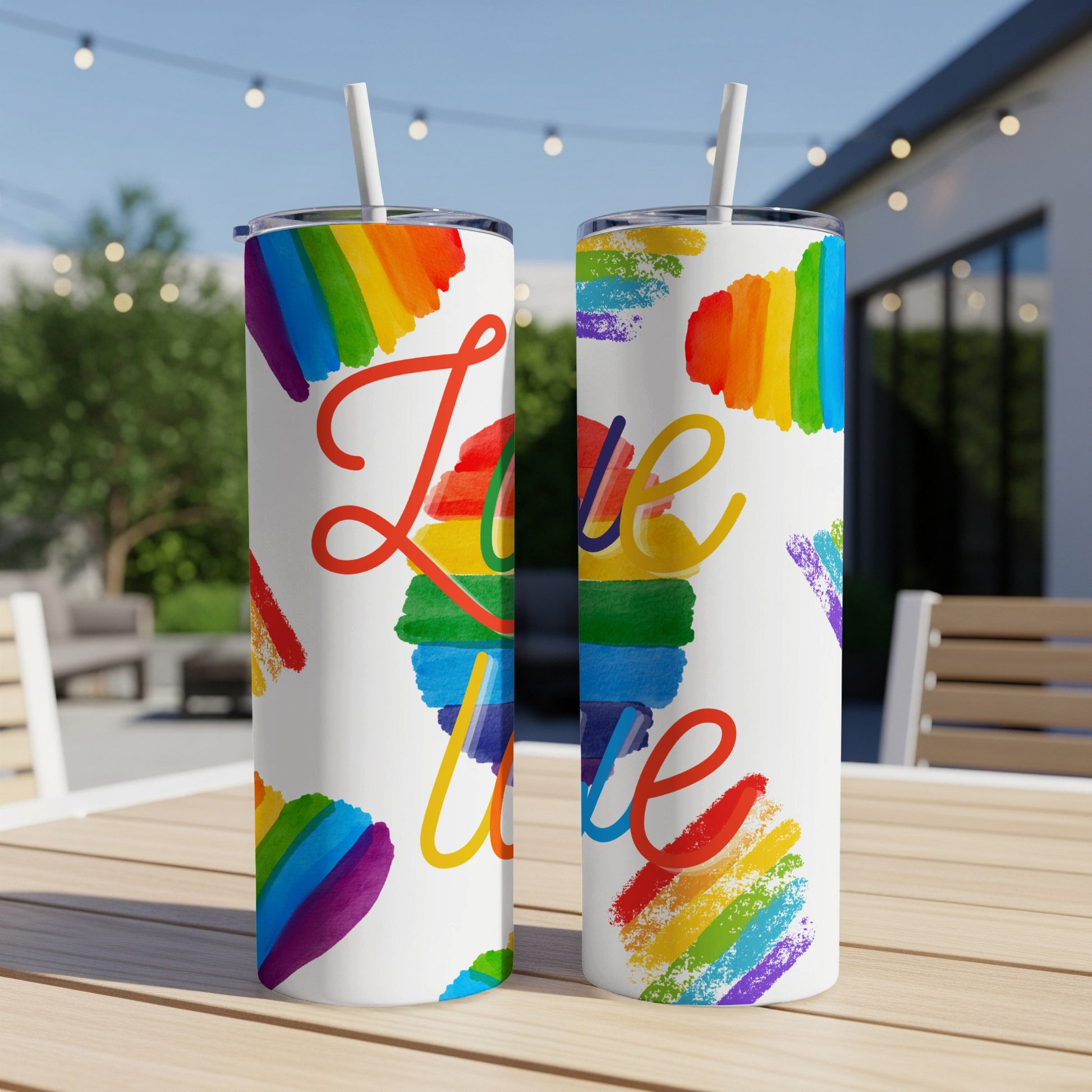 Rainbow watercolor love design on two white tumblers with straws.