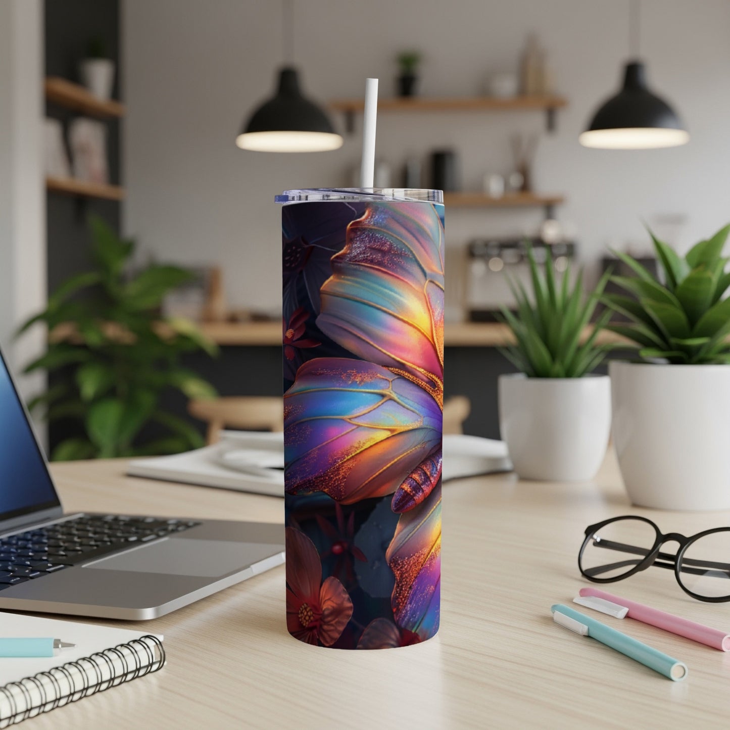 Rainbow butterfly tumbler on a desk with a laptop and pens.