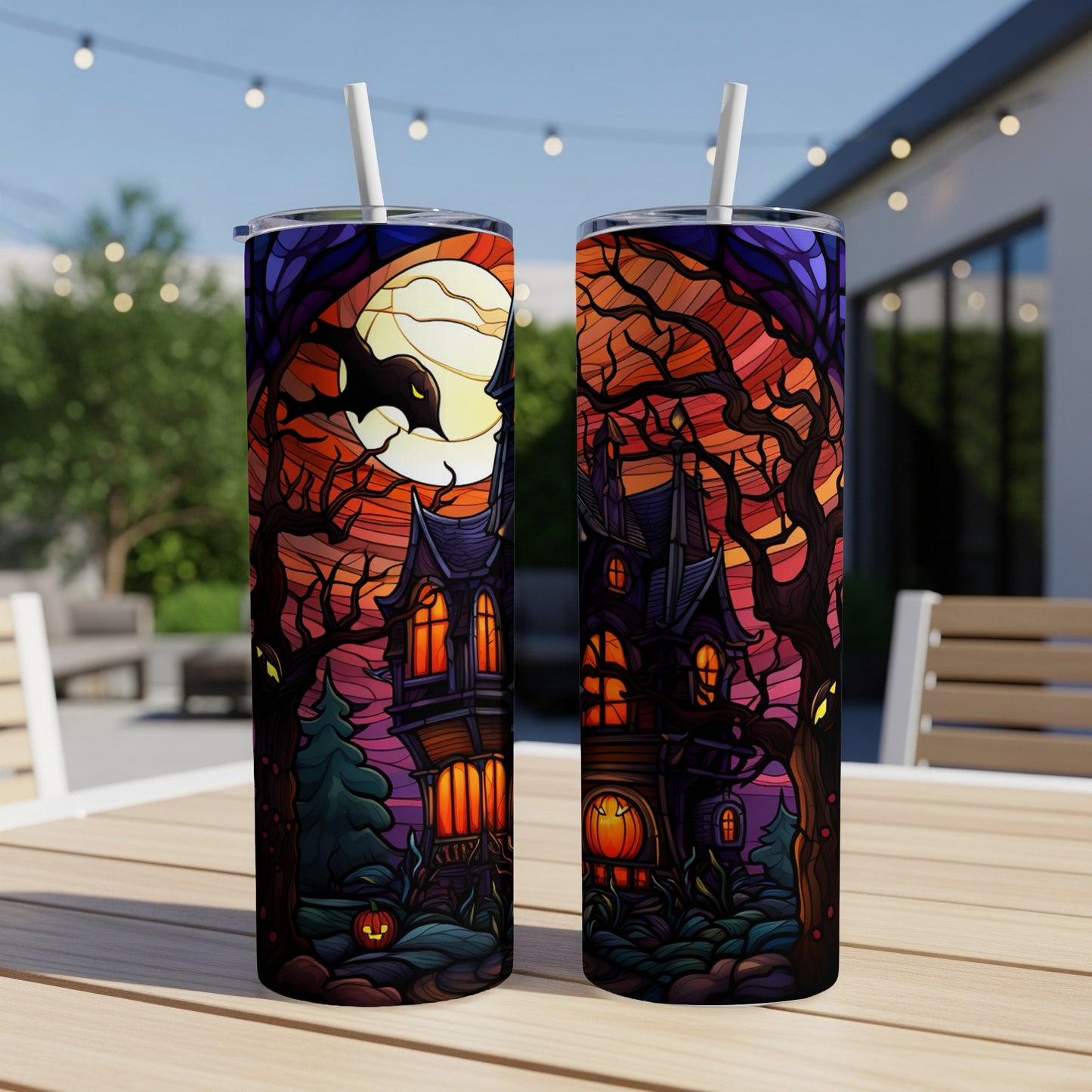Spooky haunted house with bat and moon Halloween design on two tumblers.