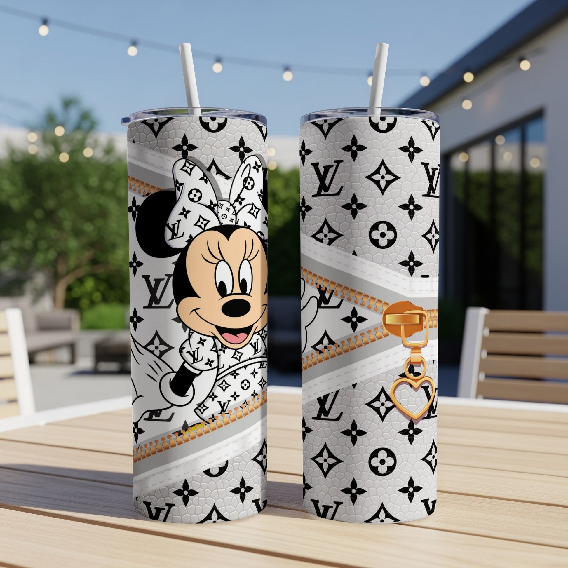 Minnie Mouse and LV pattern on two white tumblers with straws on a table.