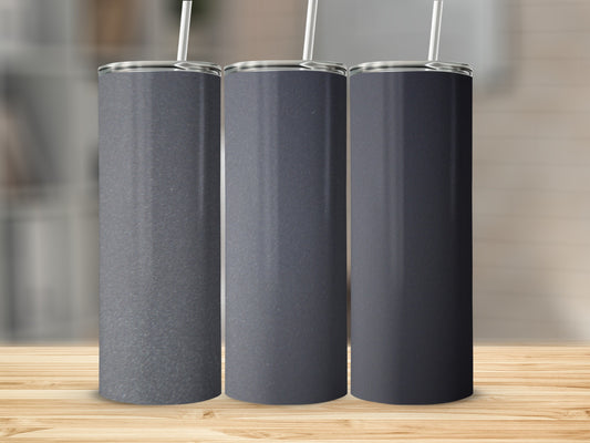 Three dark grey tumblers with straws on a wooden surface.