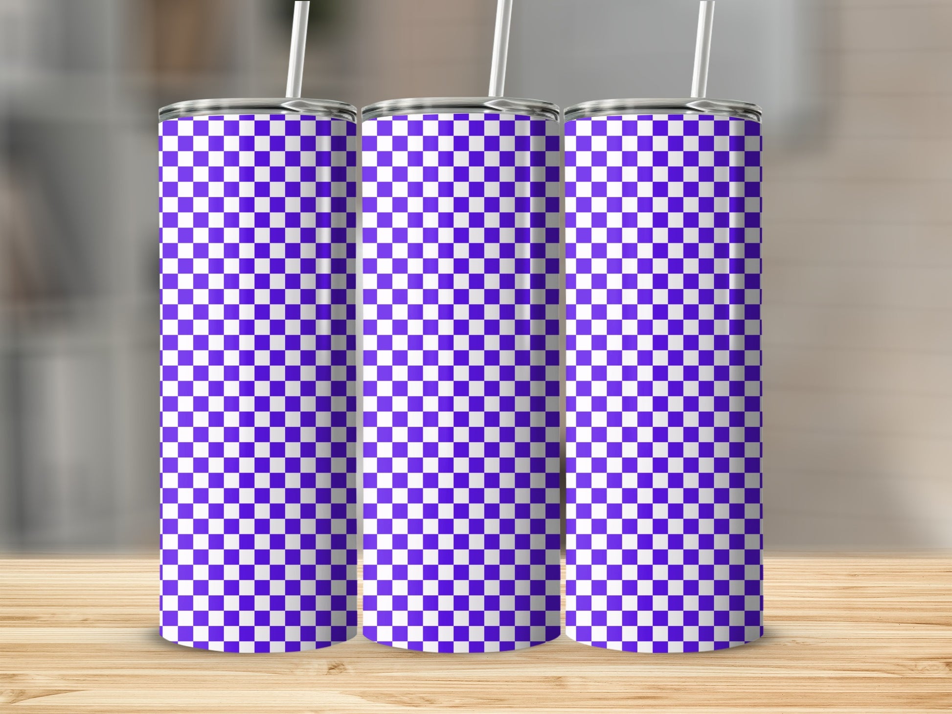 Three purple and white checkered tumblers with straws on a wooden surface.