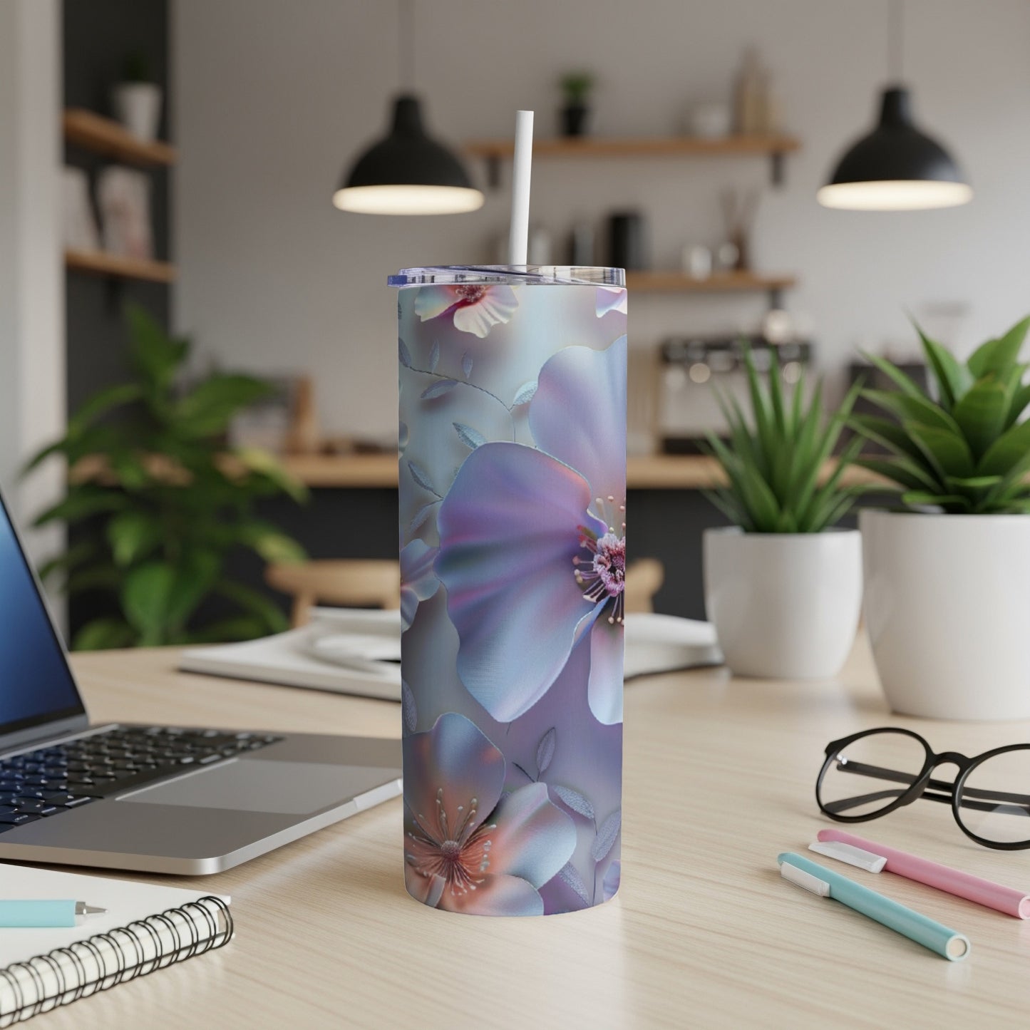 Purple floral tumbler with straw on a desk with a laptop.