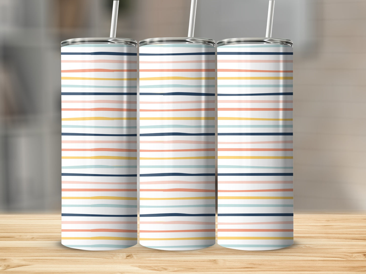 Three tumblers with colorful horizontal stripes stand on a wooden surface.