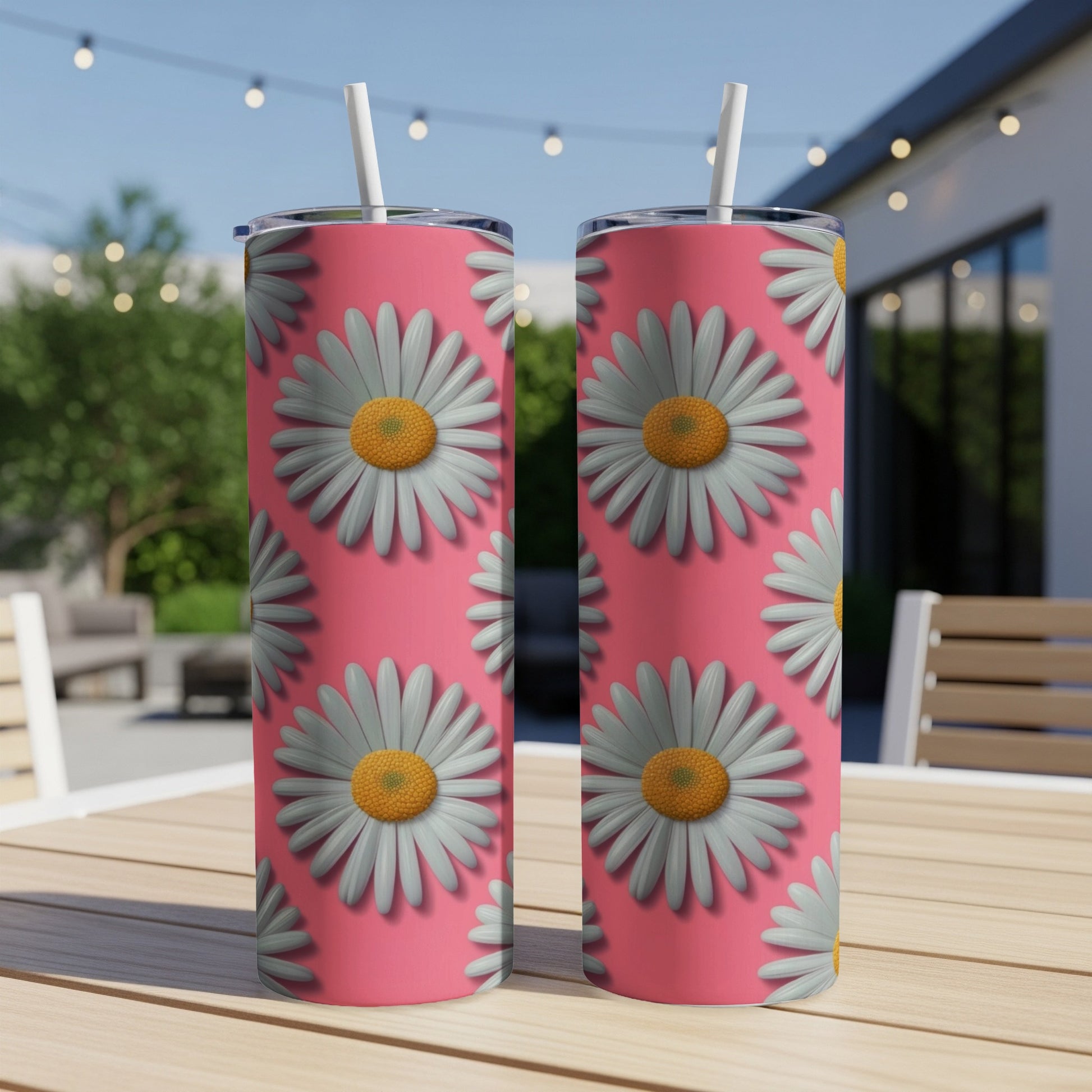 Pink tumbler with repeating daisy pattern and white straws.
