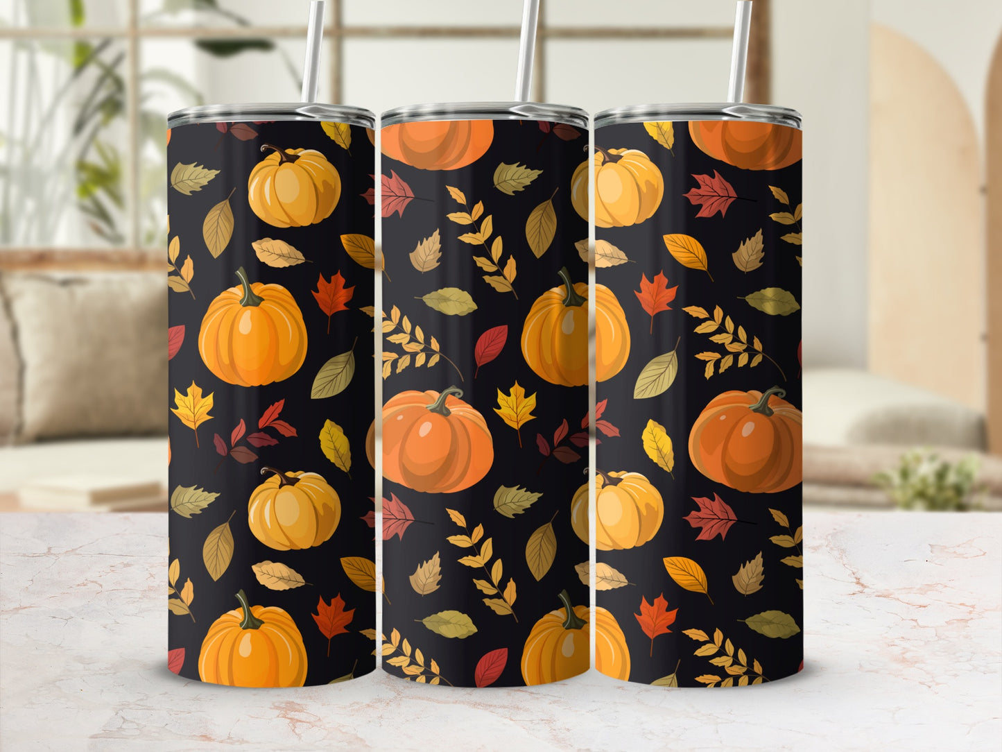 Three tumblers with a fall pumpkin and leaf pattern on a marble surface.
