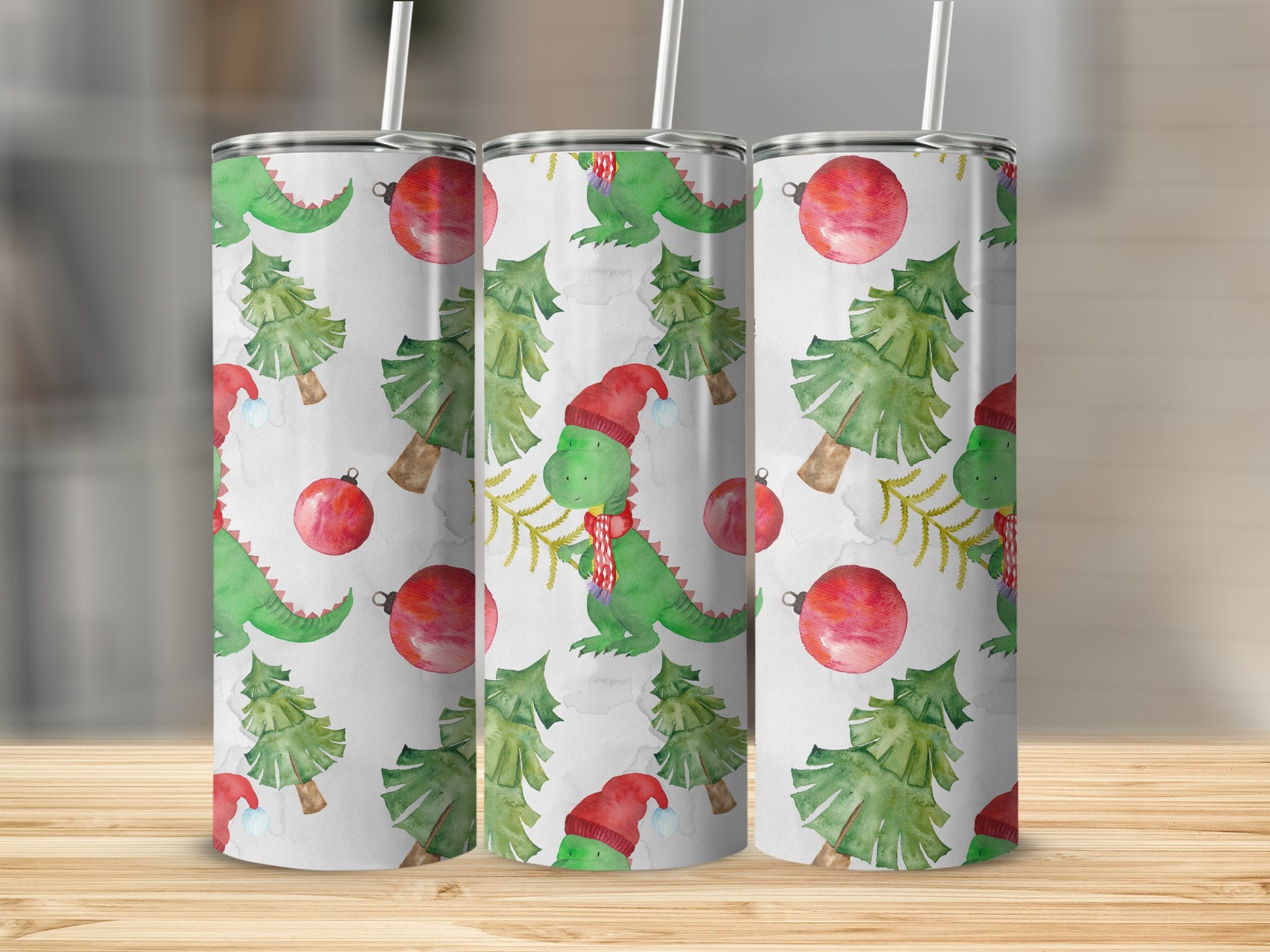 Three tumblers with a Christmas dinosaur, tree, and ornament pattern.