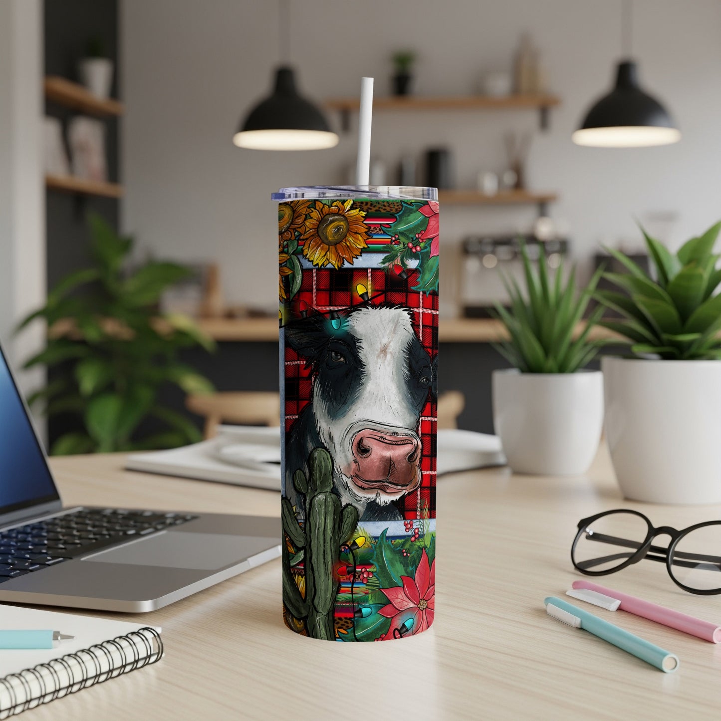 Cow with sunflowers, cacti, and poinsettias on a red plaid tumbler.
