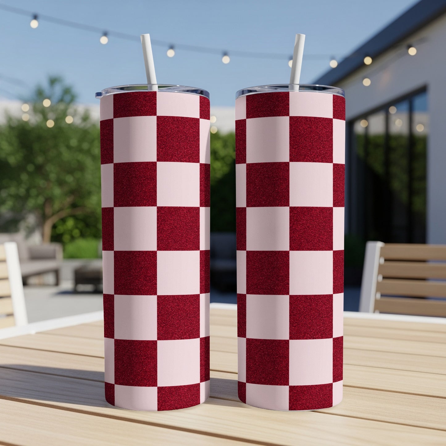 Two tall, pink tumblers with a maroon checkered pattern and straws.