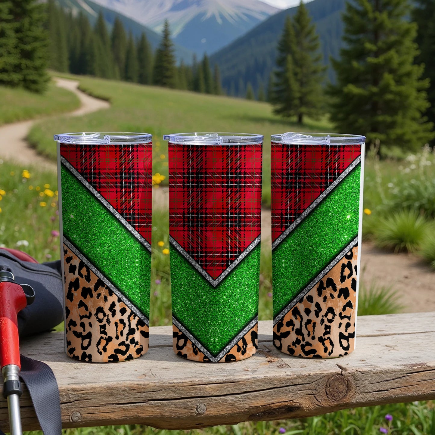 Three tumblers with plaid, glitter, and leopard print patterns on a wooden surface.