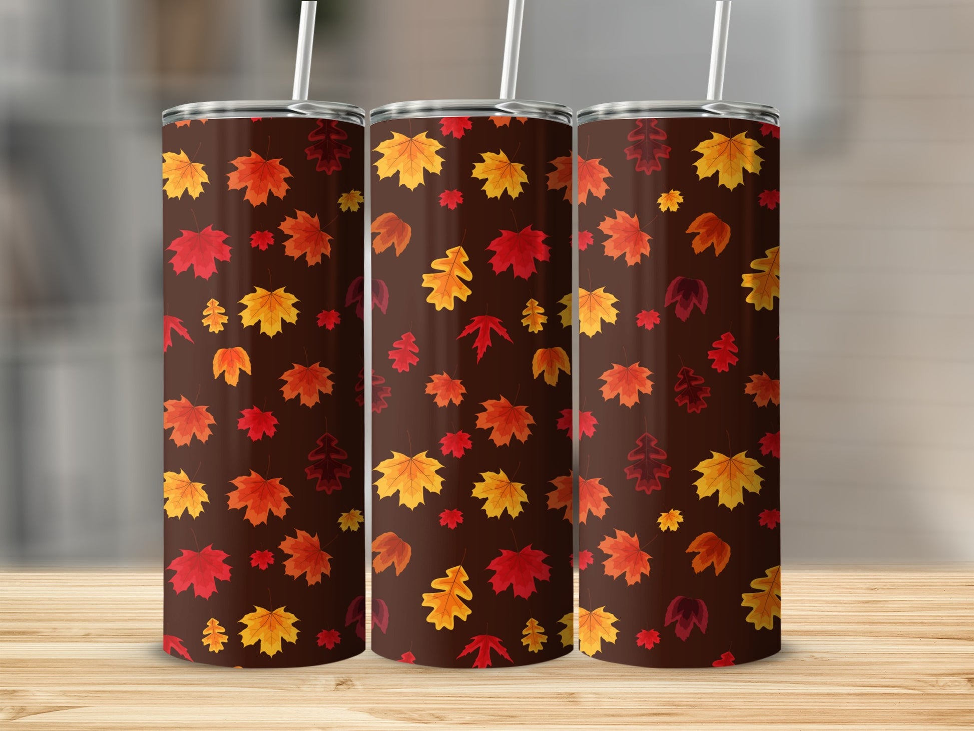 Three brown tumblers with repeating autumn leaf pattern.