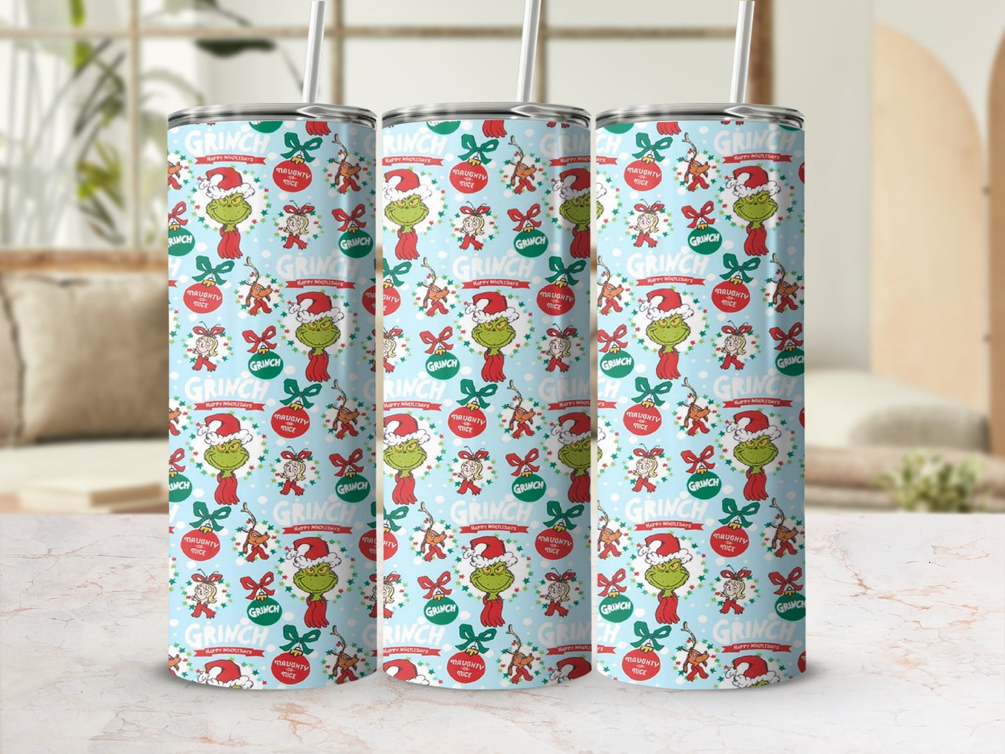 Grinch holiday pattern on three tumblers with straws.