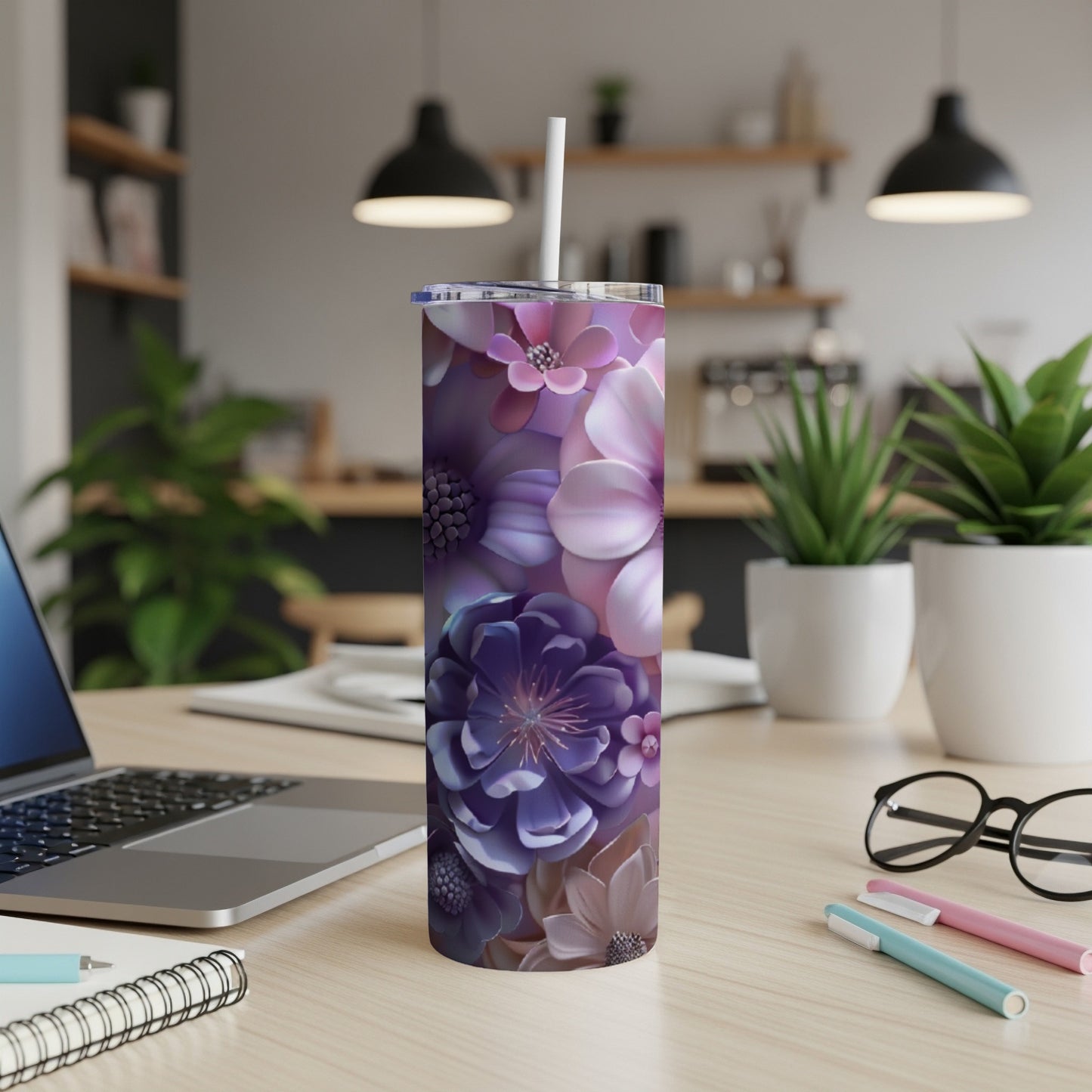 Purple floral tumbler with straw on a desk.