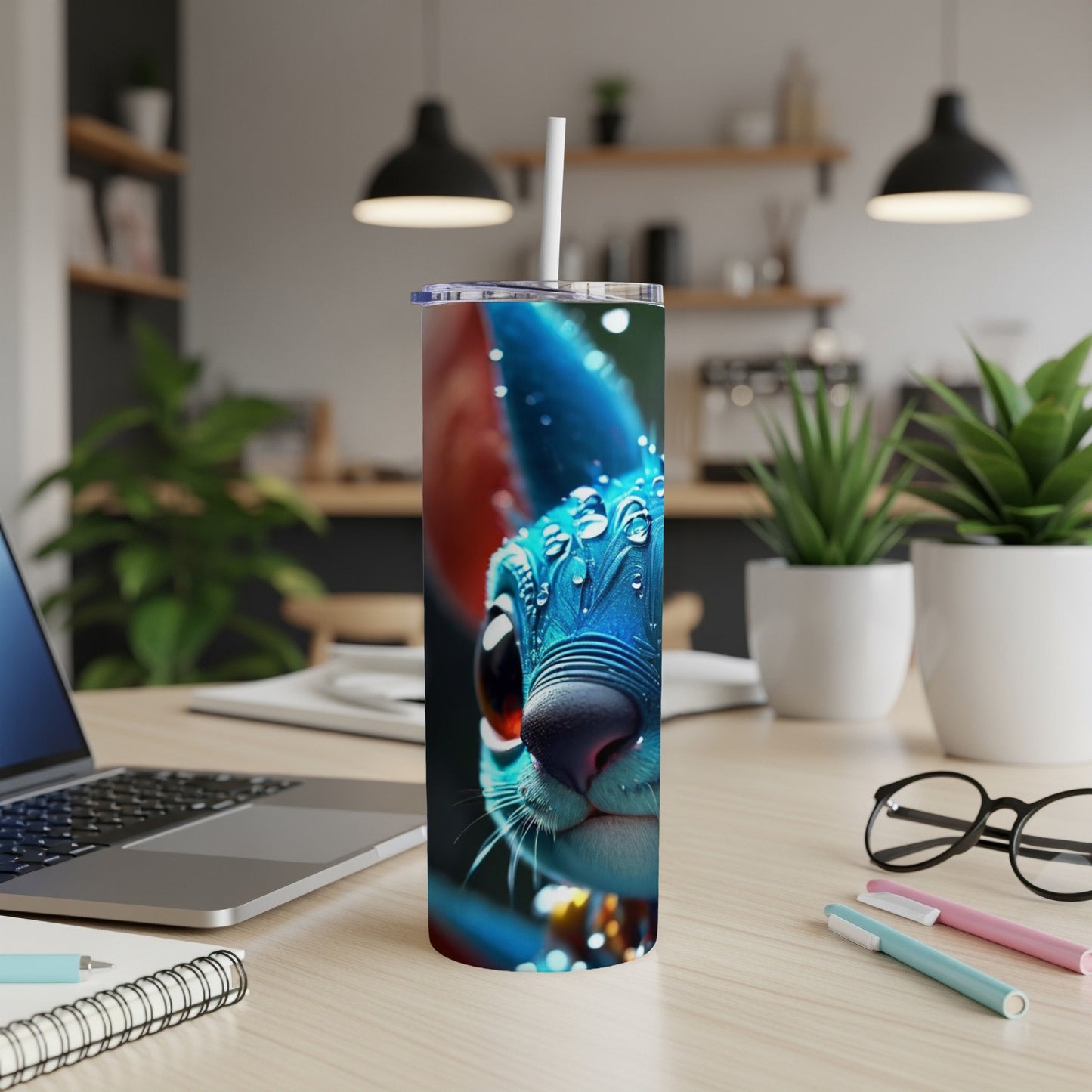 Blue cartoon cat tumbler with straw on a desk.