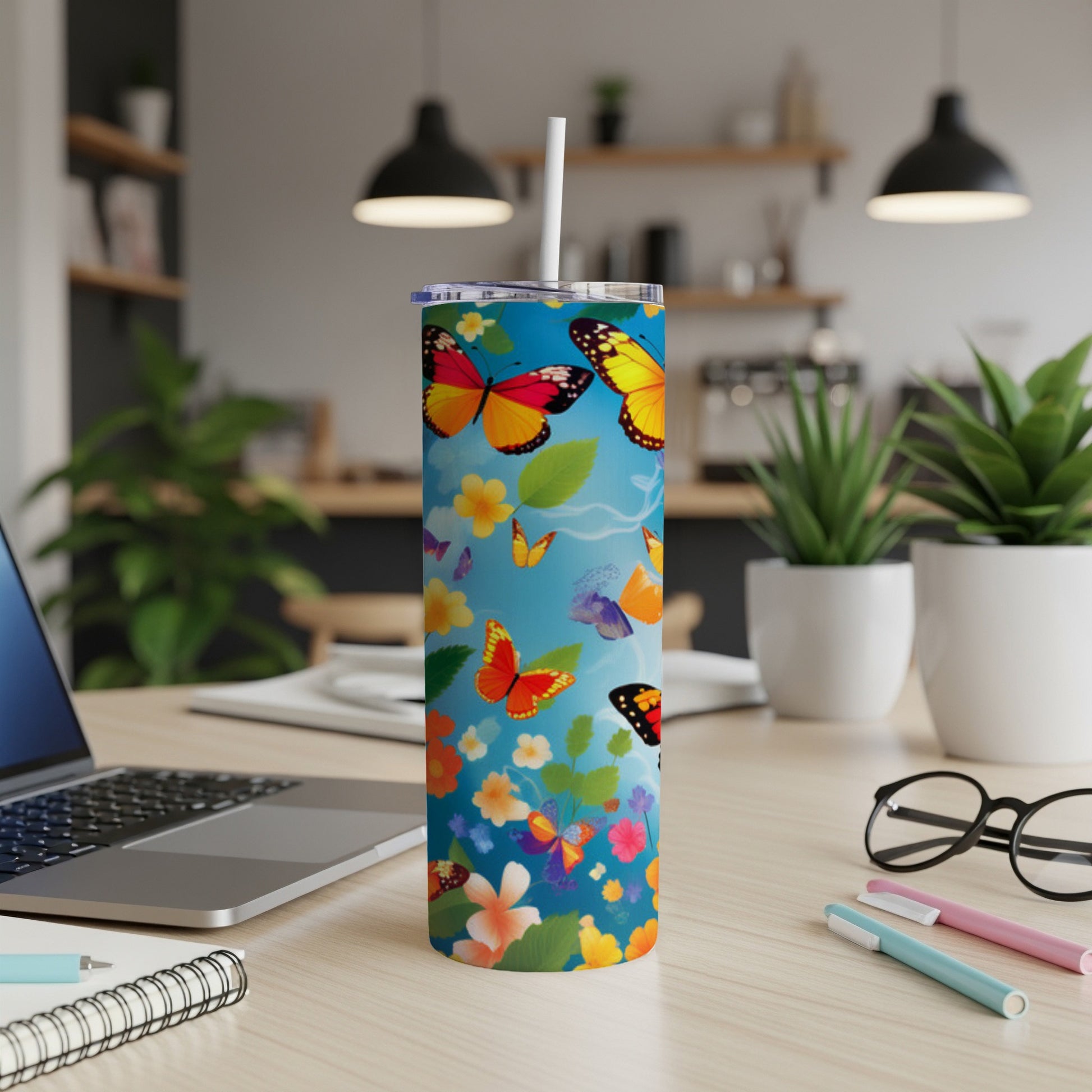 Blue skinny tumbler with colorful butterflies and floral pattern.