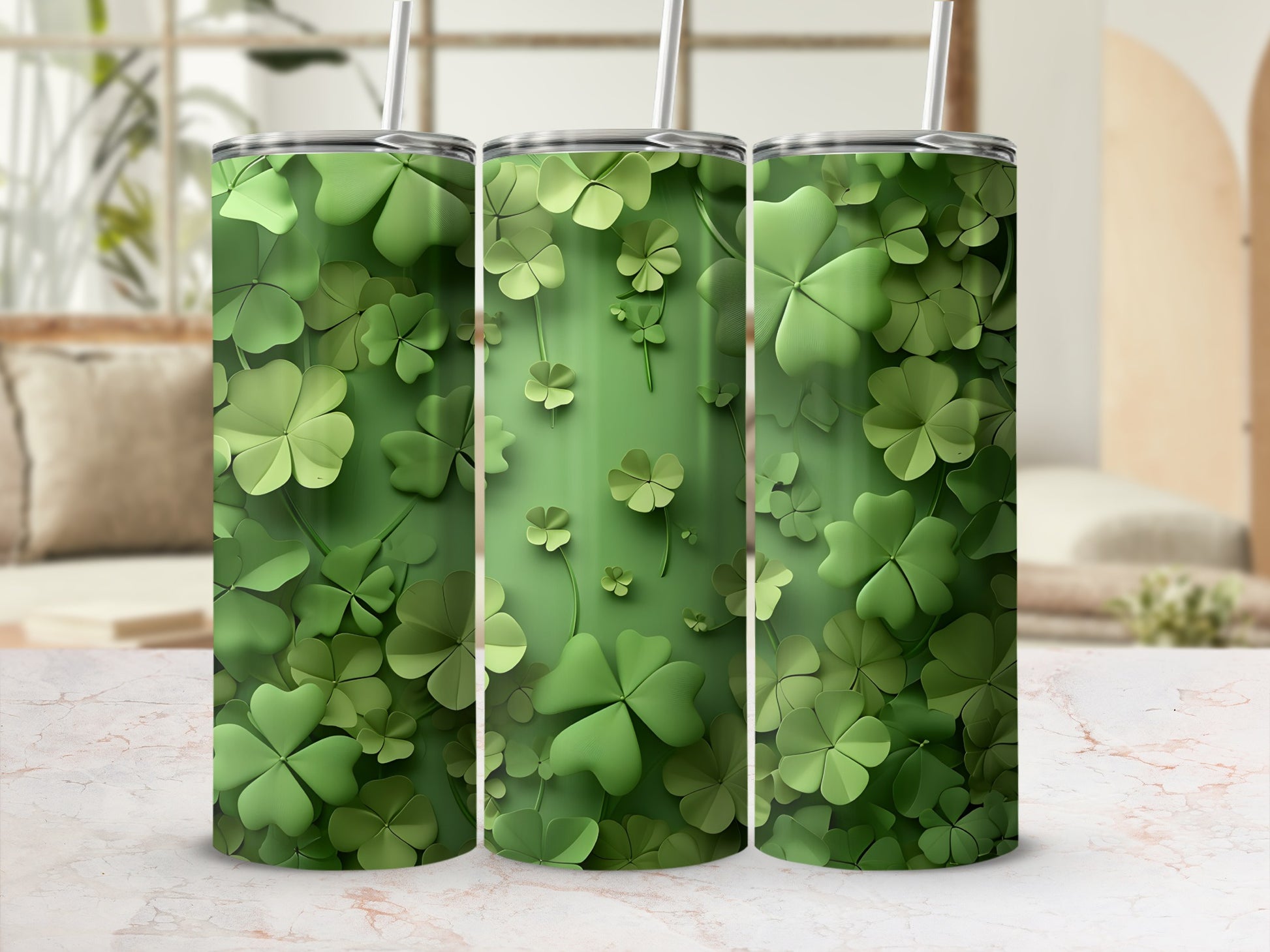 Three green tumblers with a shamrock pattern on a marbled surface.