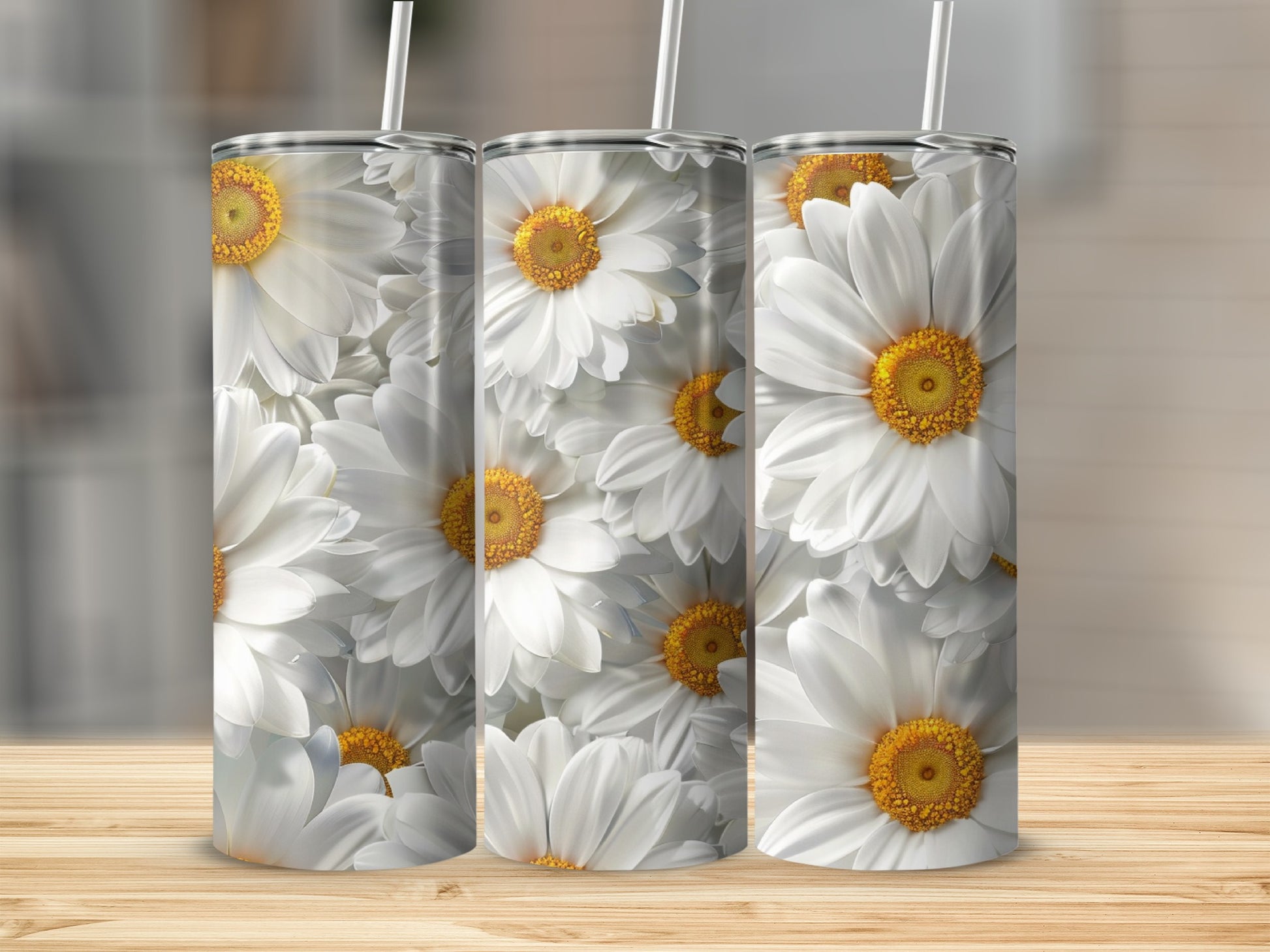 Three tumblers with a white daisy floral pattern on a wooden surface.