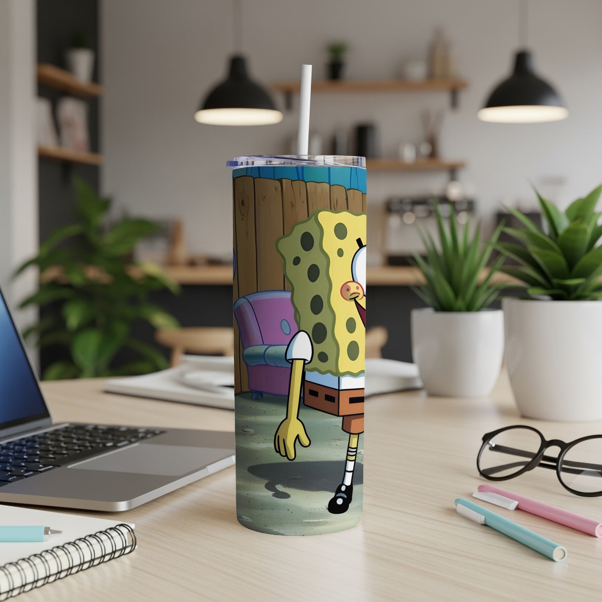 SpongeBob SquarePants character on a tumbler with a straw, on a desk.