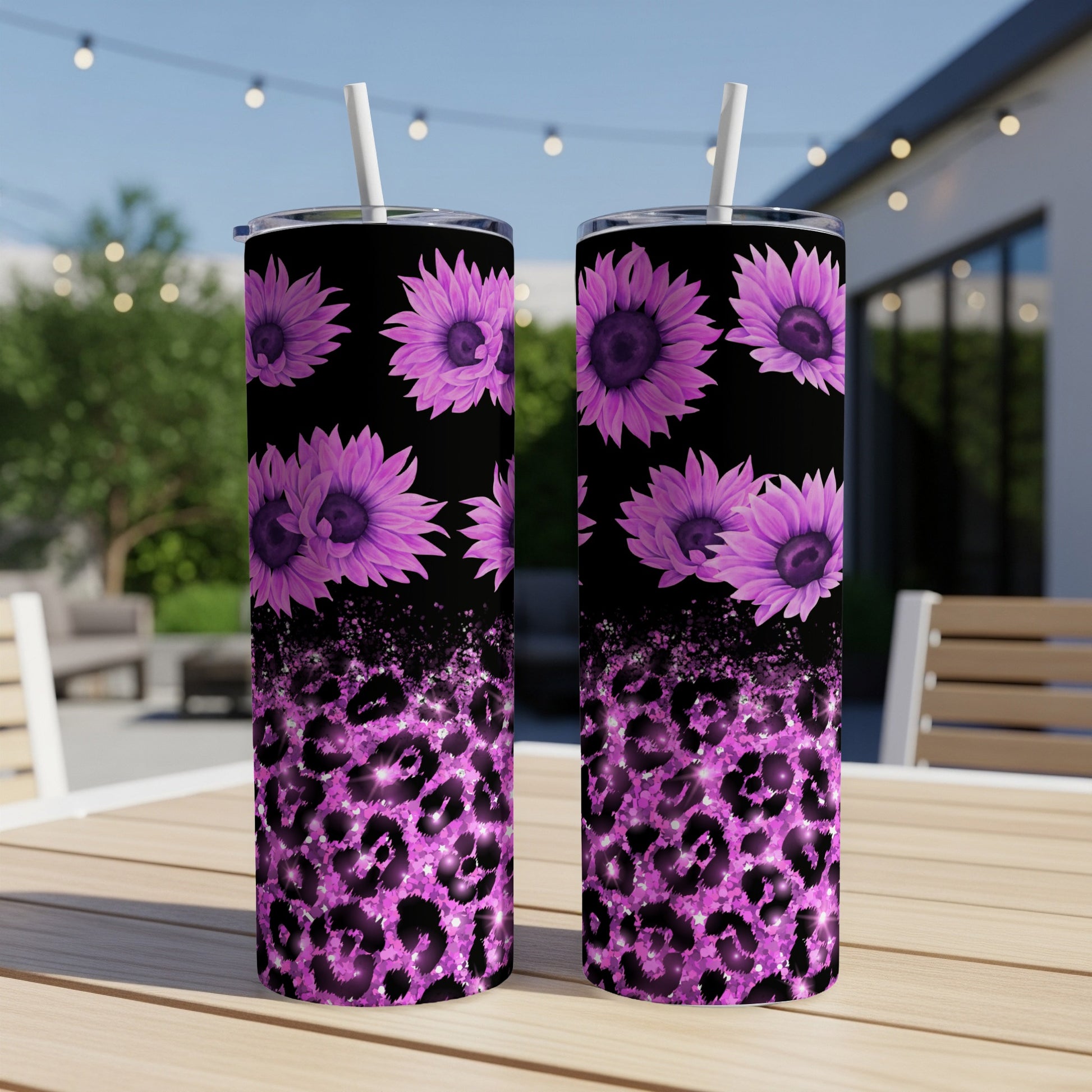Two tumblers with purple sunflowers and pink leopard print on a table.