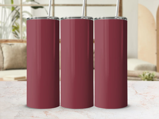 Three burgundy tumblers with straws on a marble countertop.