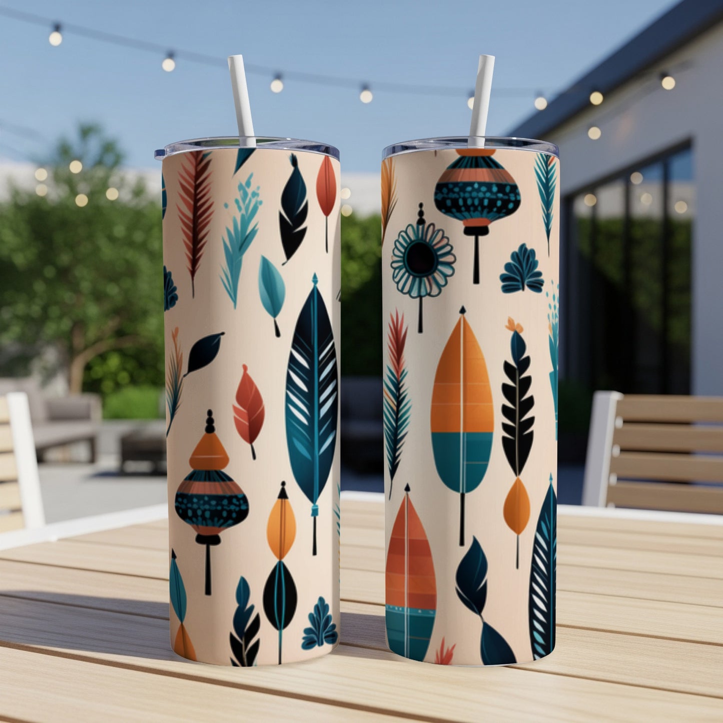 Two tan tumblers with a colorful feather and lantern pattern on a wooden table.