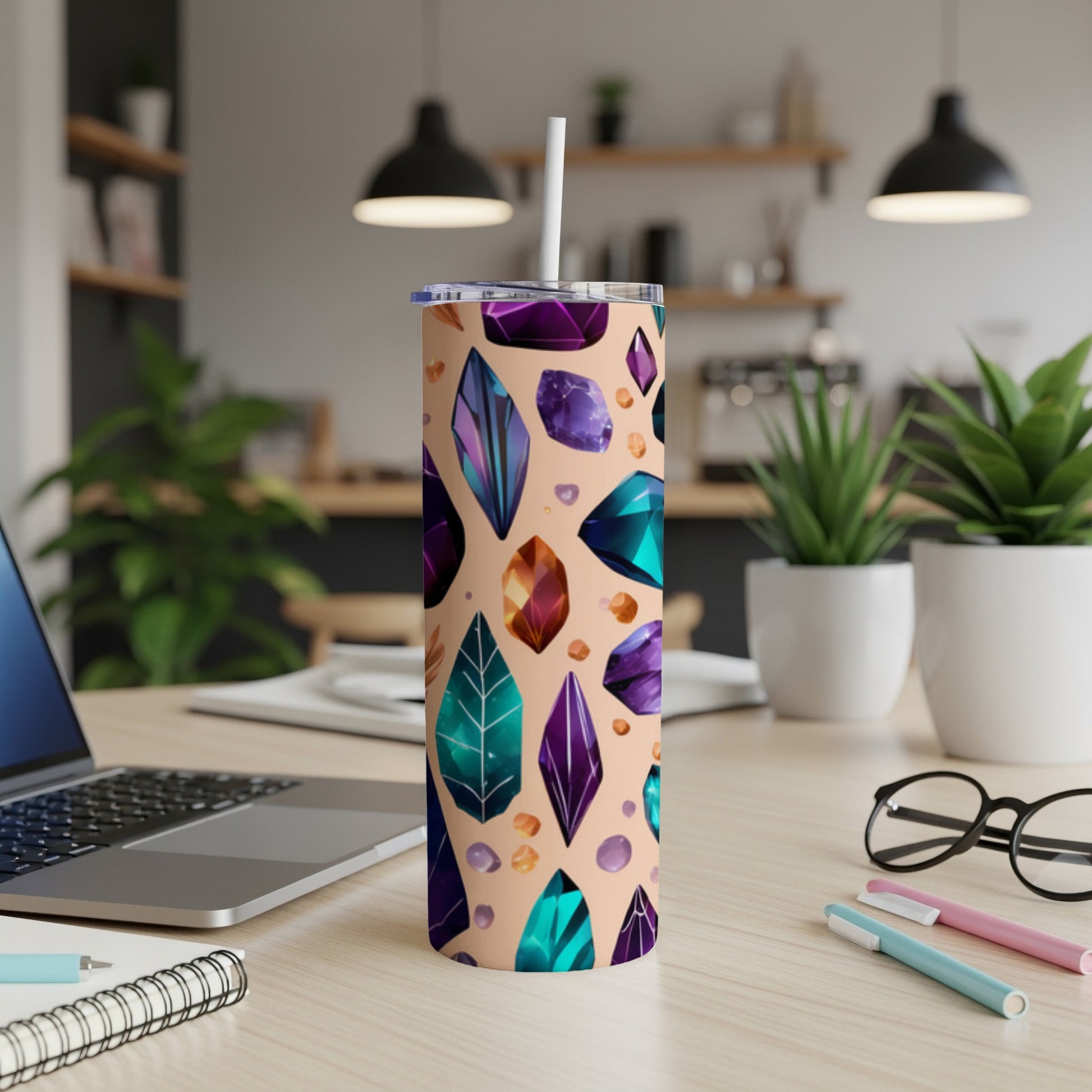 Tall tumbler with colorful crystal pattern and straw on a desk.
