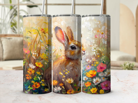 Three tumblers with floral bunny art, set against a blurred background.