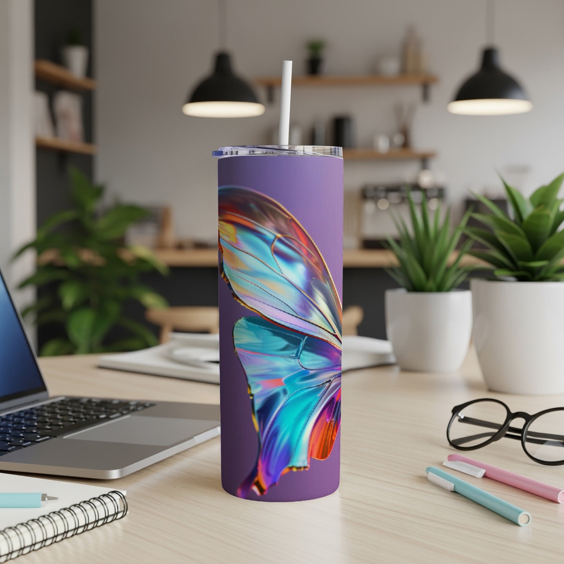Purple tumbler with iridescent butterfly wing design on a desk.