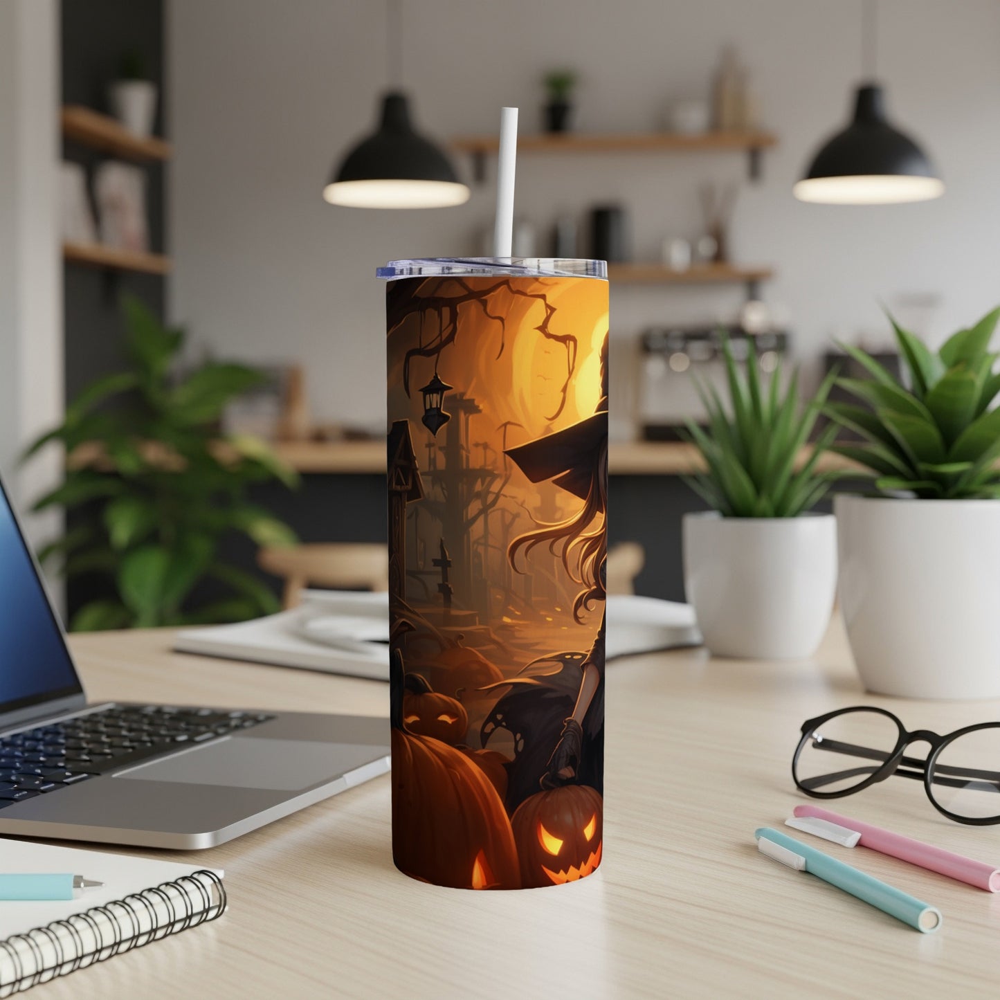 Tumbler with Halloween witch and pumpkin design on a desk.