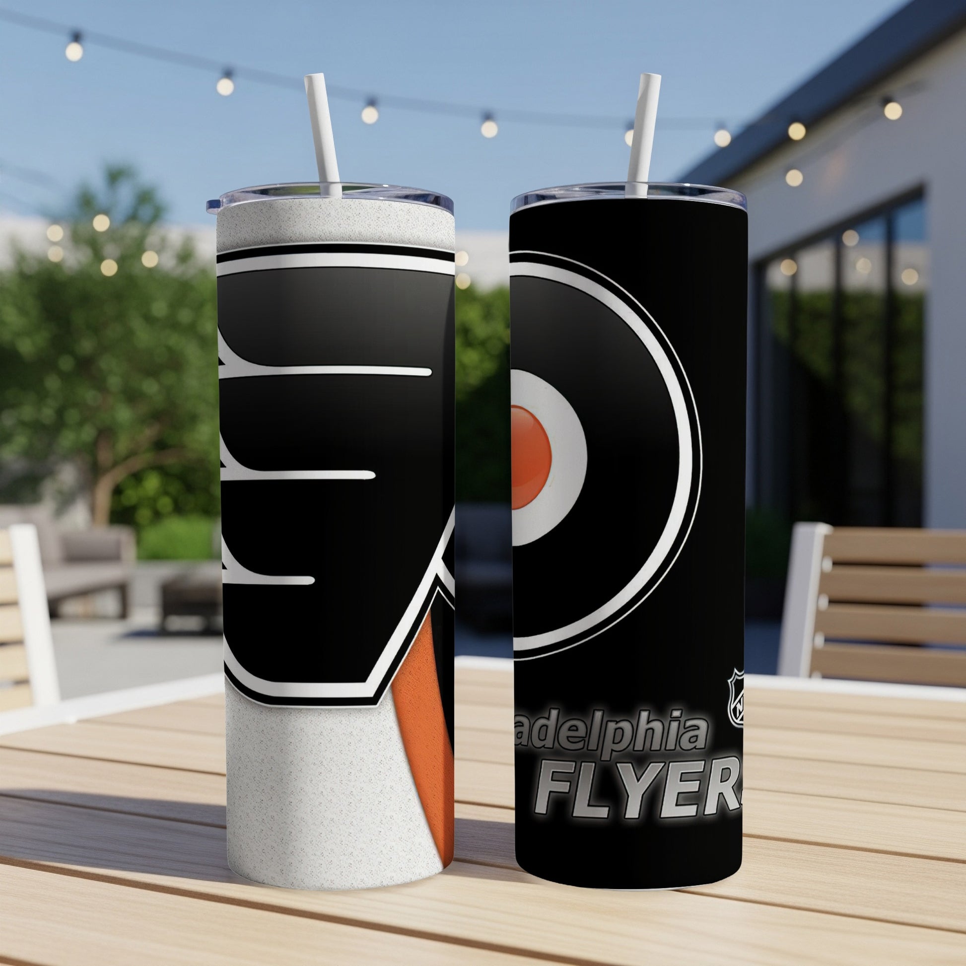 Philadelphia Flyers tumblers with straws on wooden table.