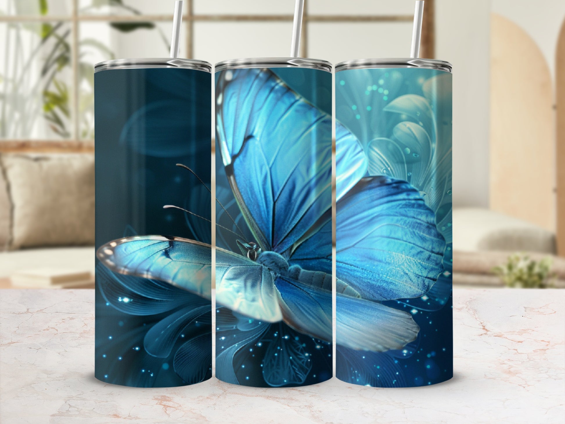 Three tumblers with vibrant blue butterfly designs and sparkling accents.