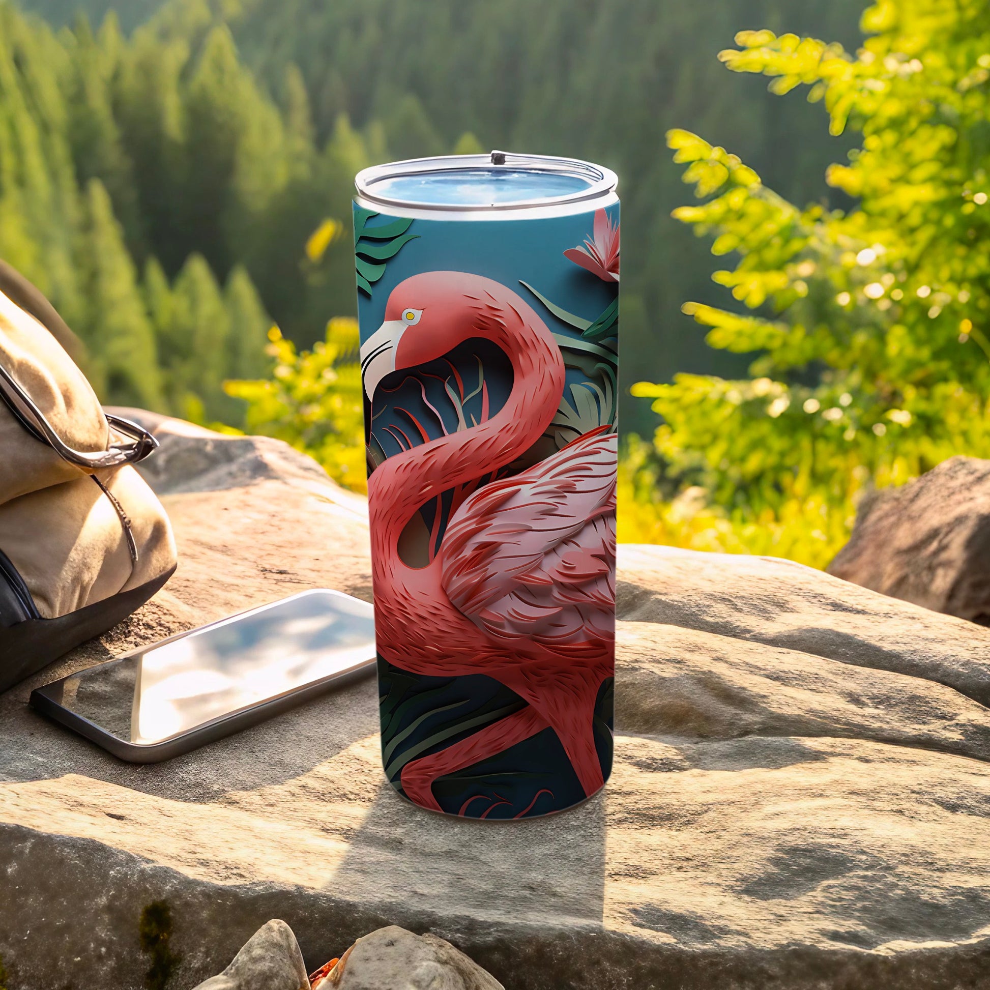 Pink flamingo illustration on a tall tumbler, surrounded by foliage.