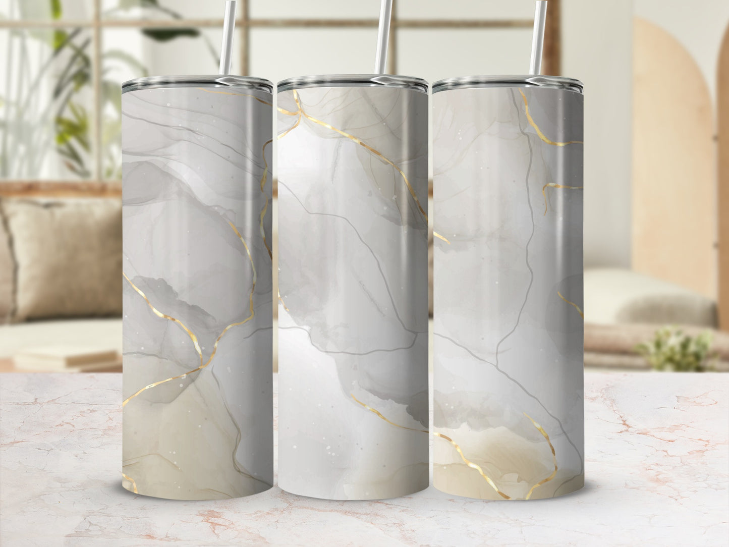 Three tumblers with marbled gray and gold abstract design and straw.