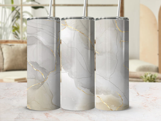 Three tumblers with marbled gray and gold abstract design and straw.