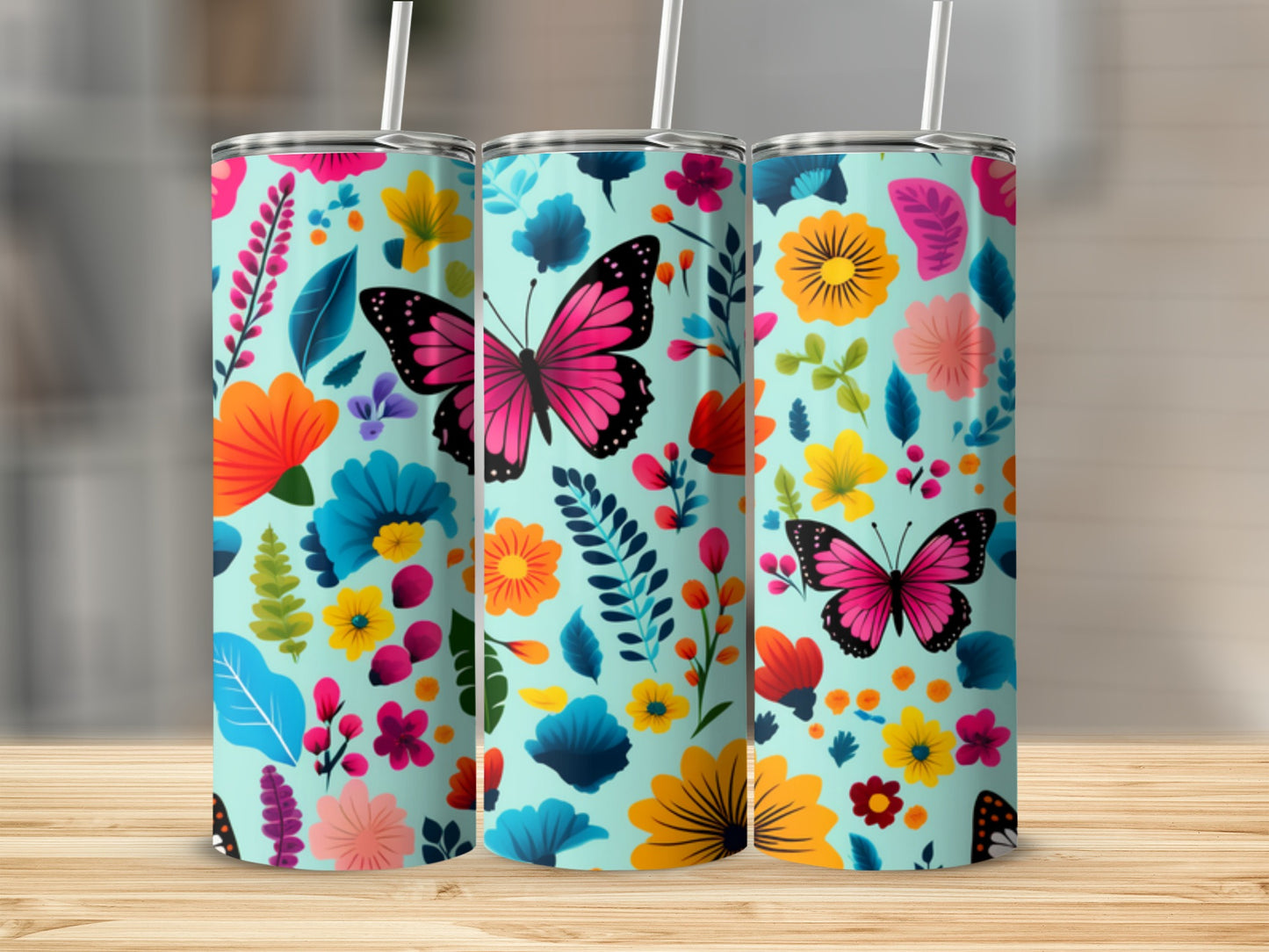 Three teal tumblers with colorful floral and butterfly designs.