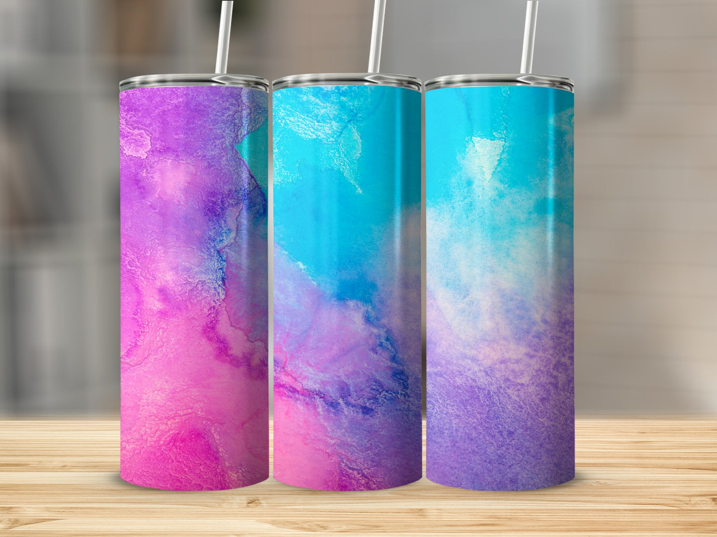 Three tall tumblers with abstract watercolor designs in pink, purple, and blue.