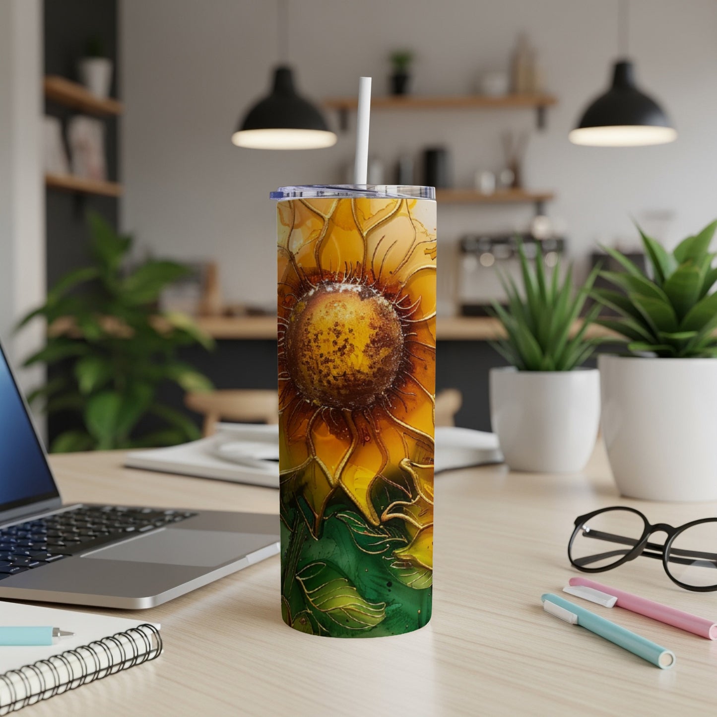 Tall tumbler with a detailed sunflower design, on a desk.