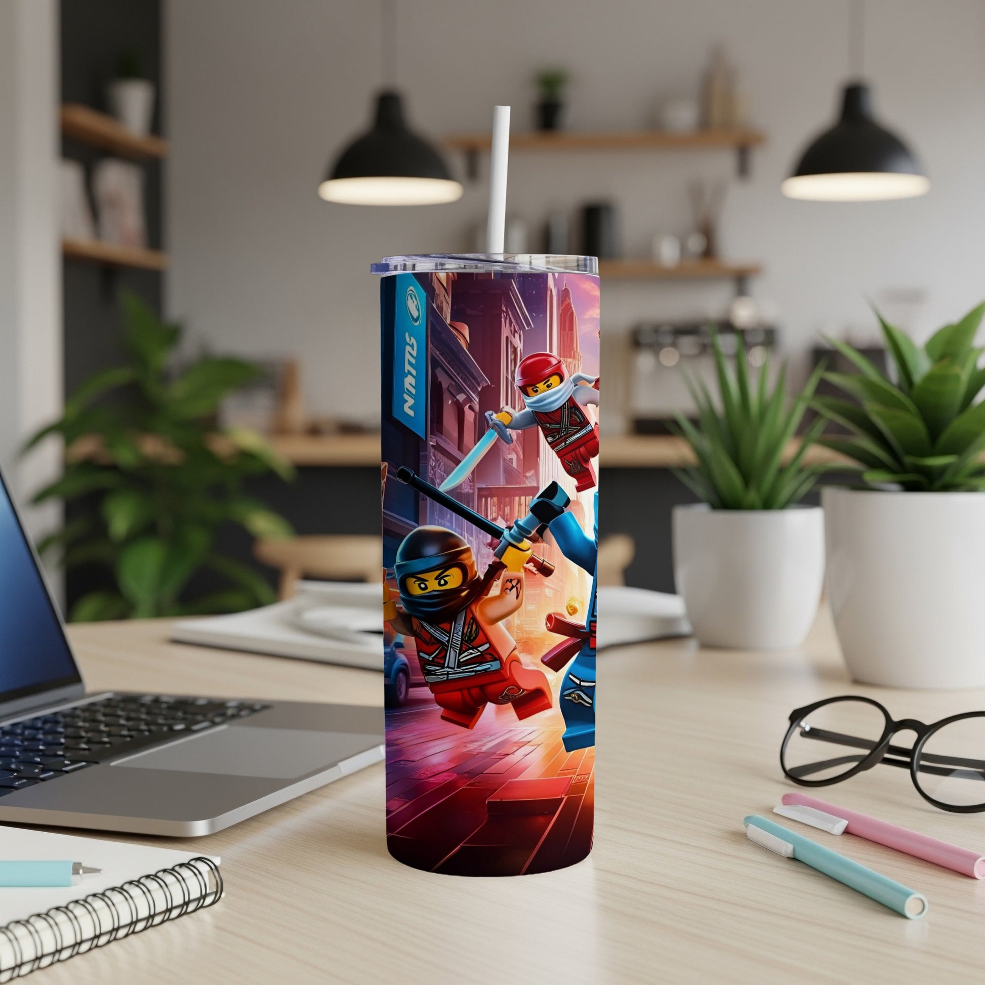 Ninjago characters in action on a tumbler with a laptop and pens.