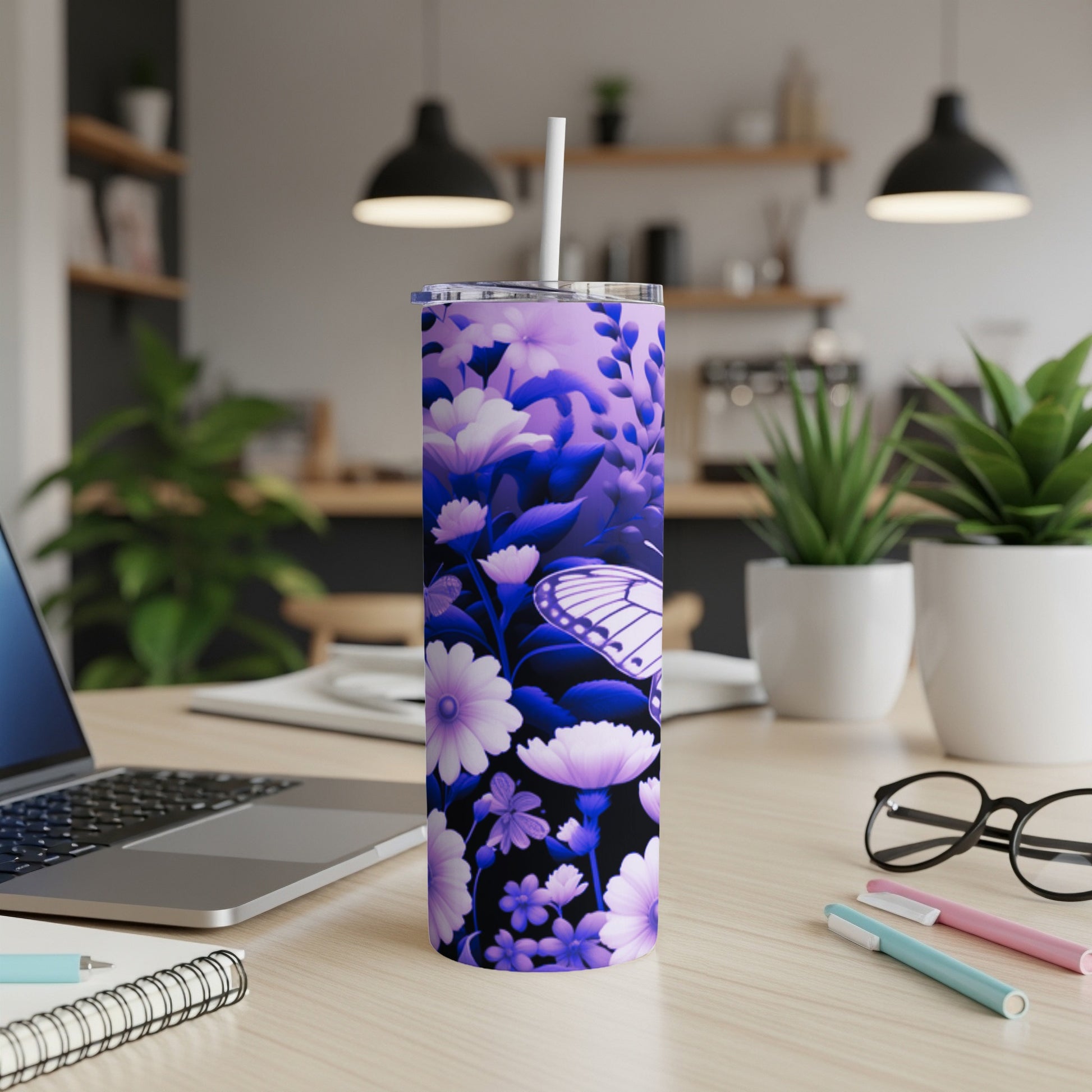 Purple floral pattern tumbler with butterfly, white lid and straw on desk.