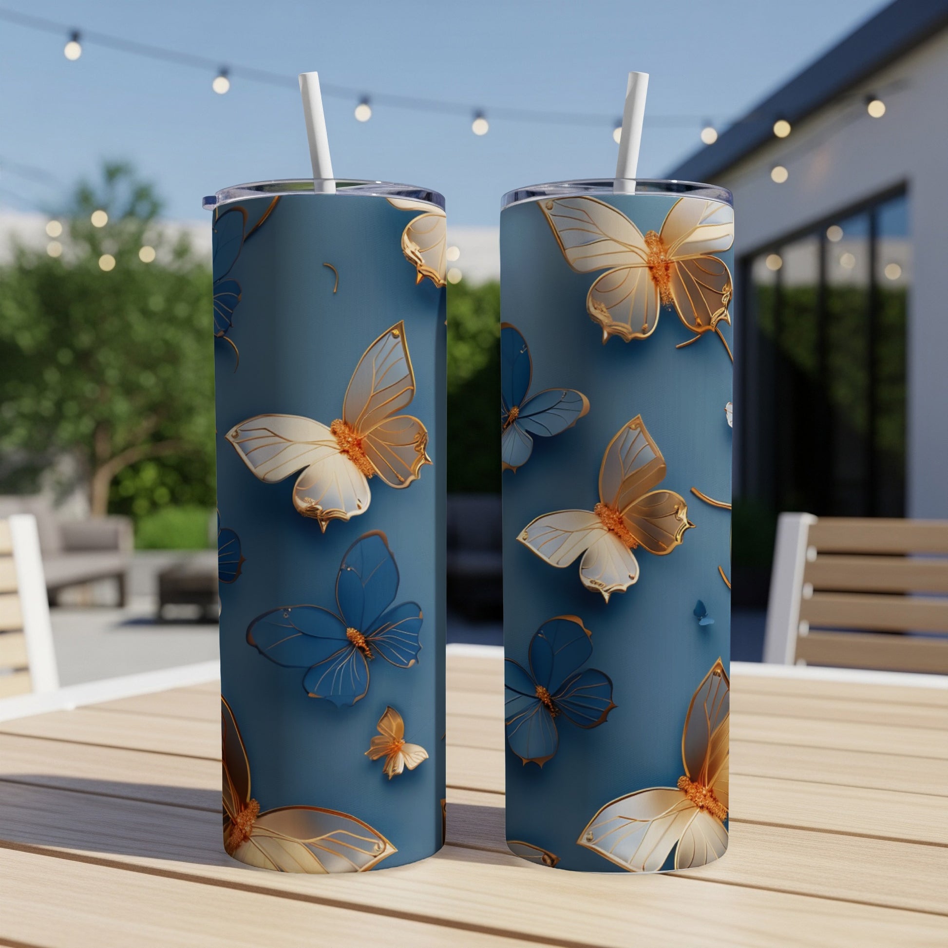 Two tall, blue tumblers with a repeating pattern of gold and blue butterflies.