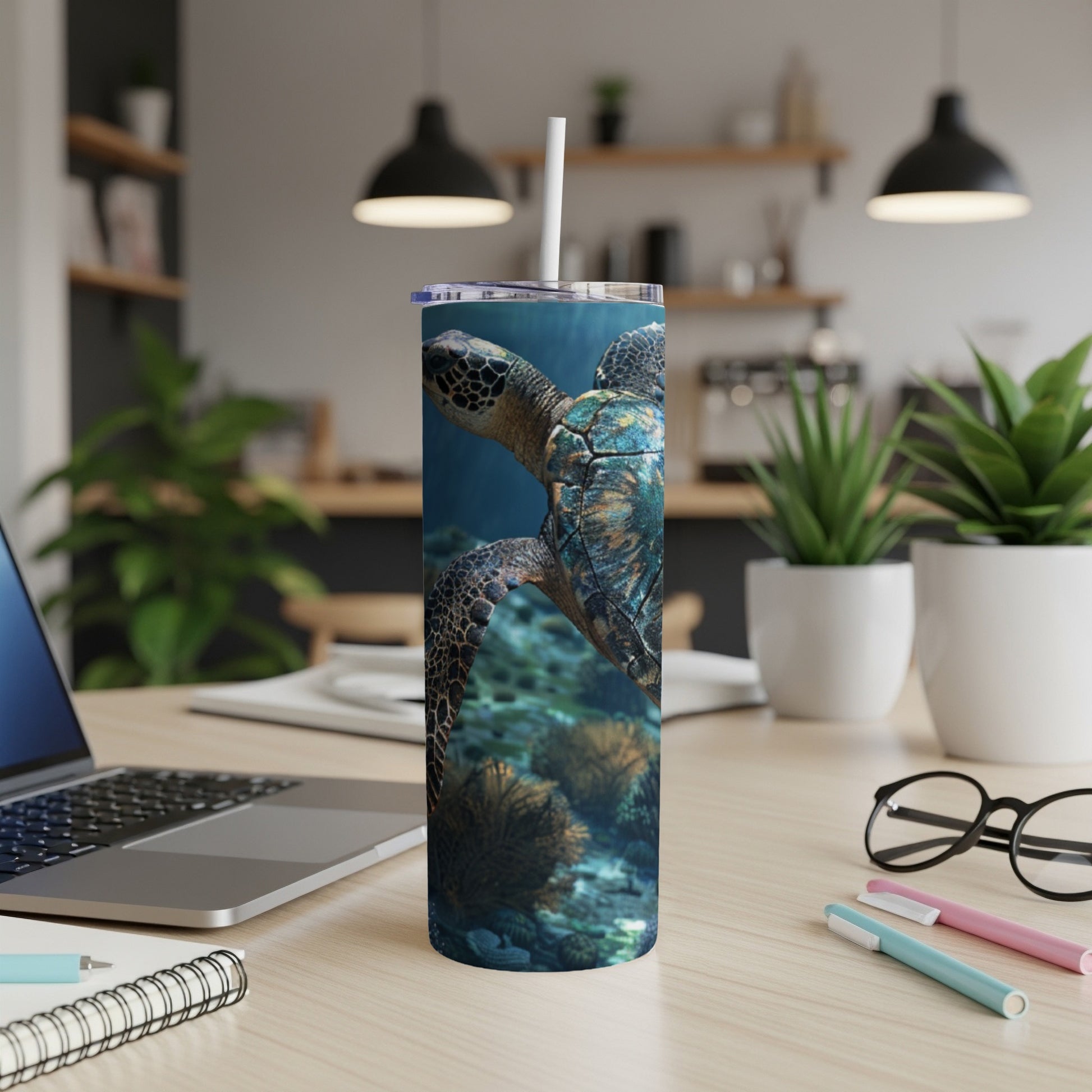 Sea turtle swimming underwater with coral and a desk with a laptop.